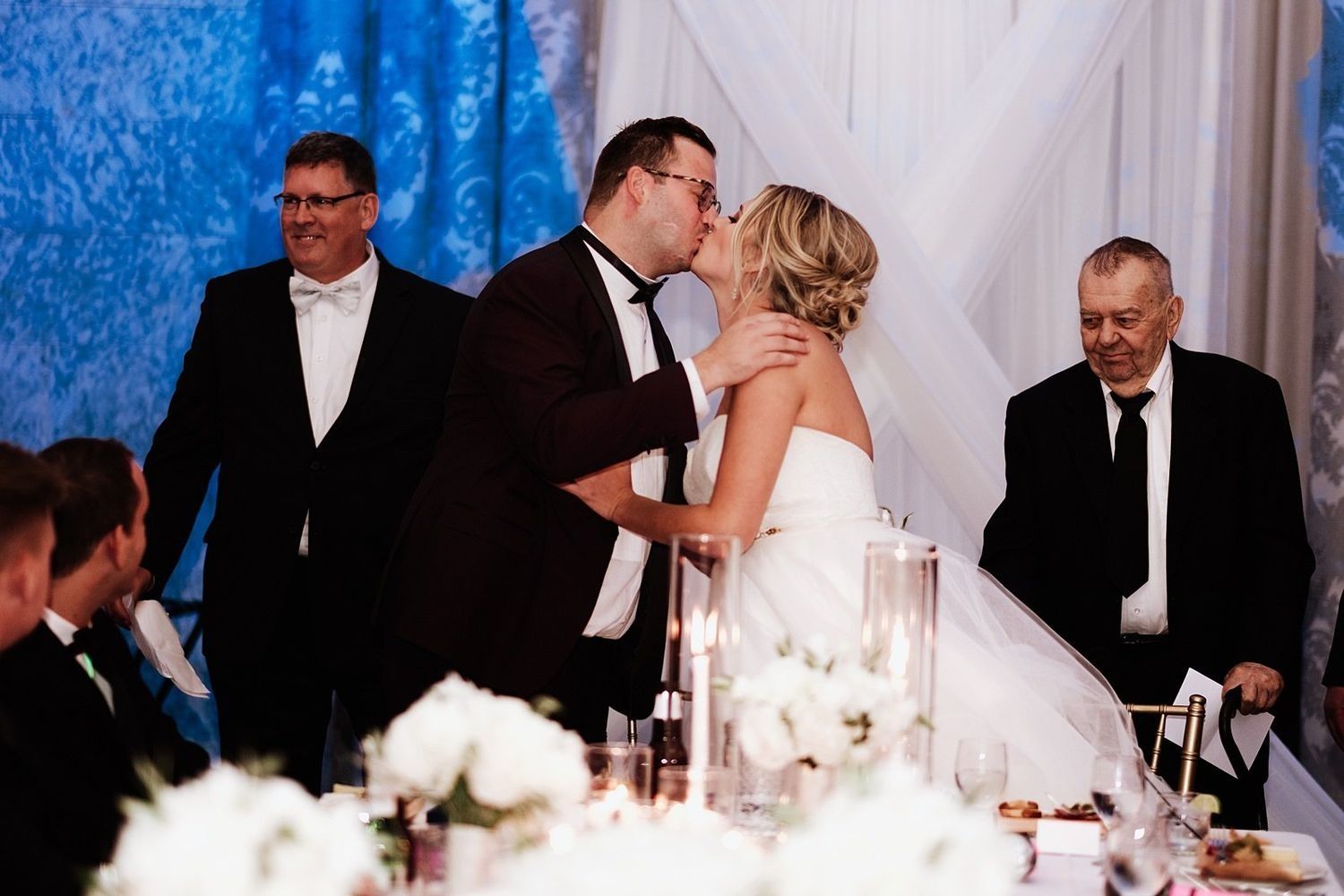 Shannon and Karel sharing a romantic kiss after cutting their wedding cake in Michigan.