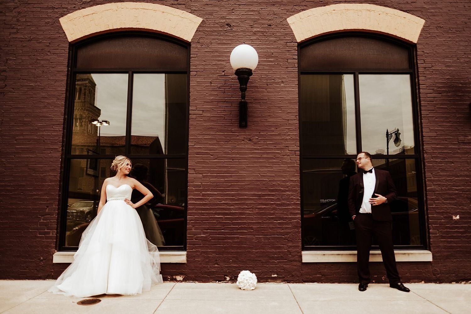 Symmetrical wedding portrait of Shannon and Karel featuring grand city windows.
