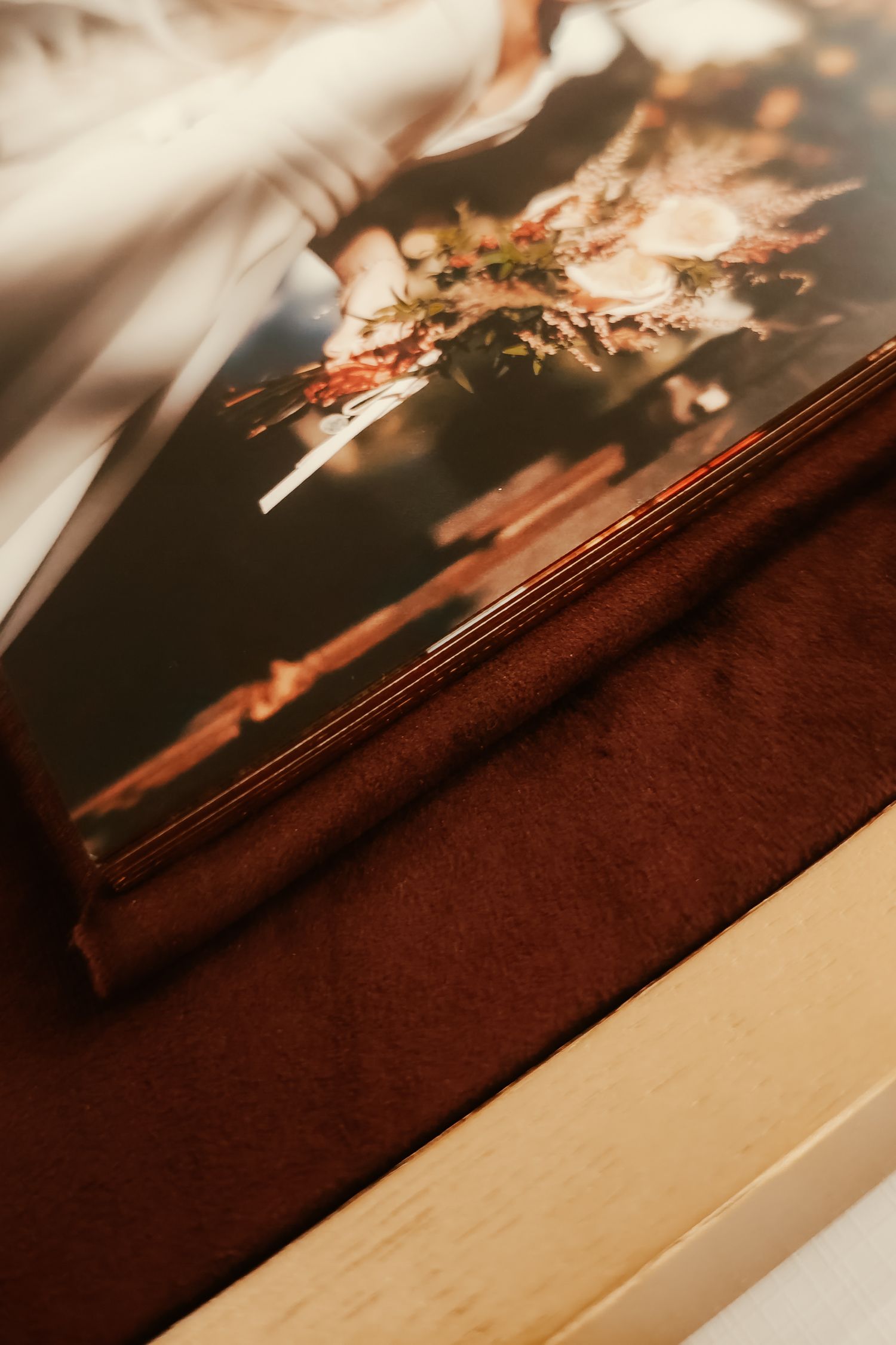 Close-up view of a brown hardcover book with blurred light reflections creating abstract patterns in warm tones.
