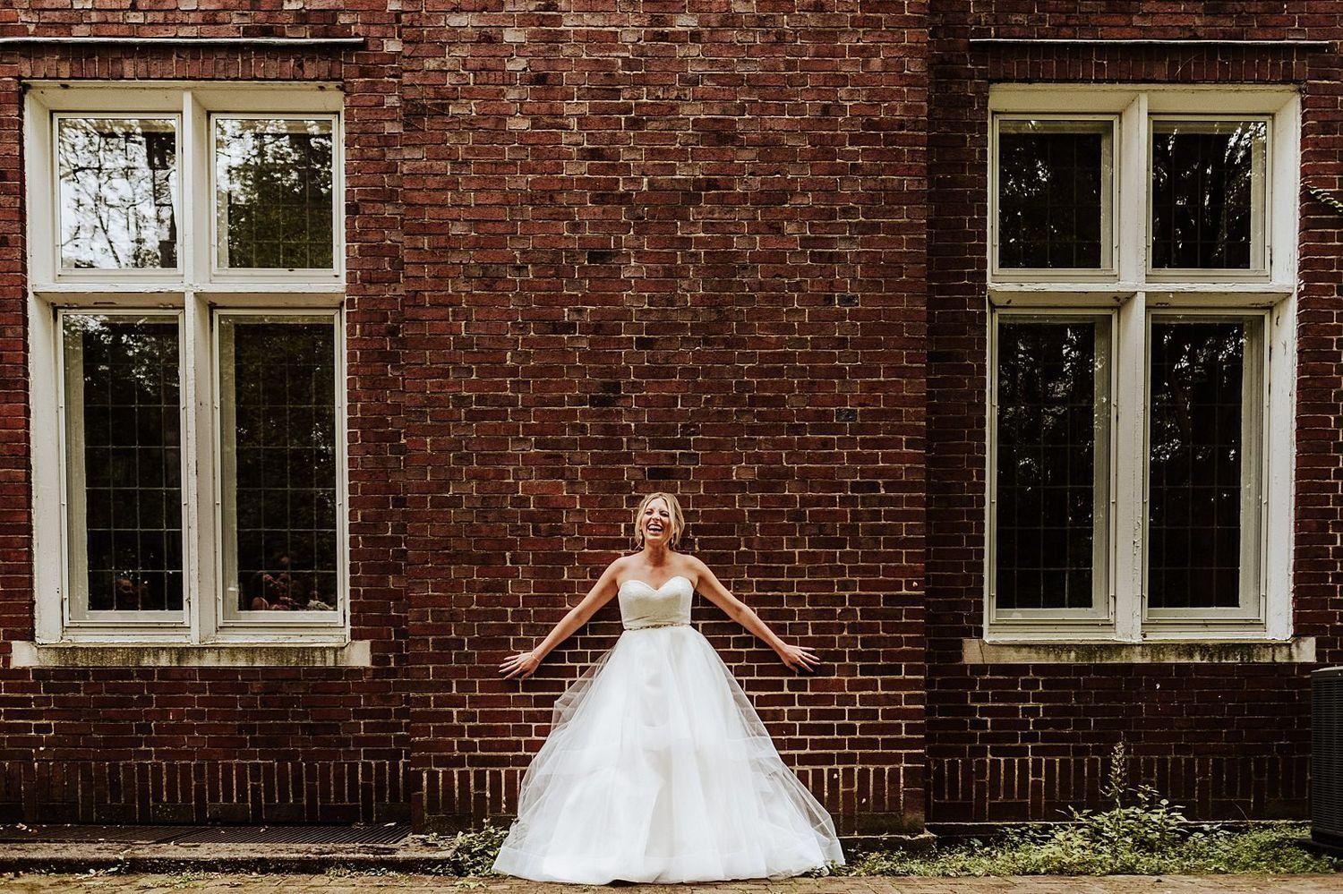 Happy bride Shannon posing in front of a historic architectural building in downtown Michigan