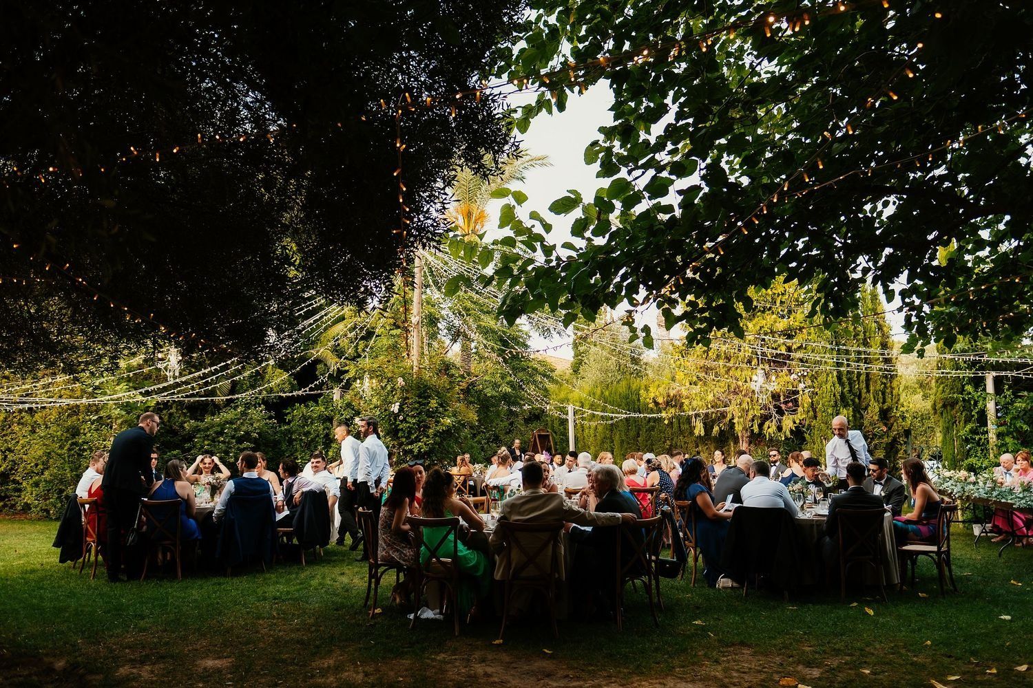 Jade y Jordan sentados en la mesa presidencial banquete de boda al aire libre
