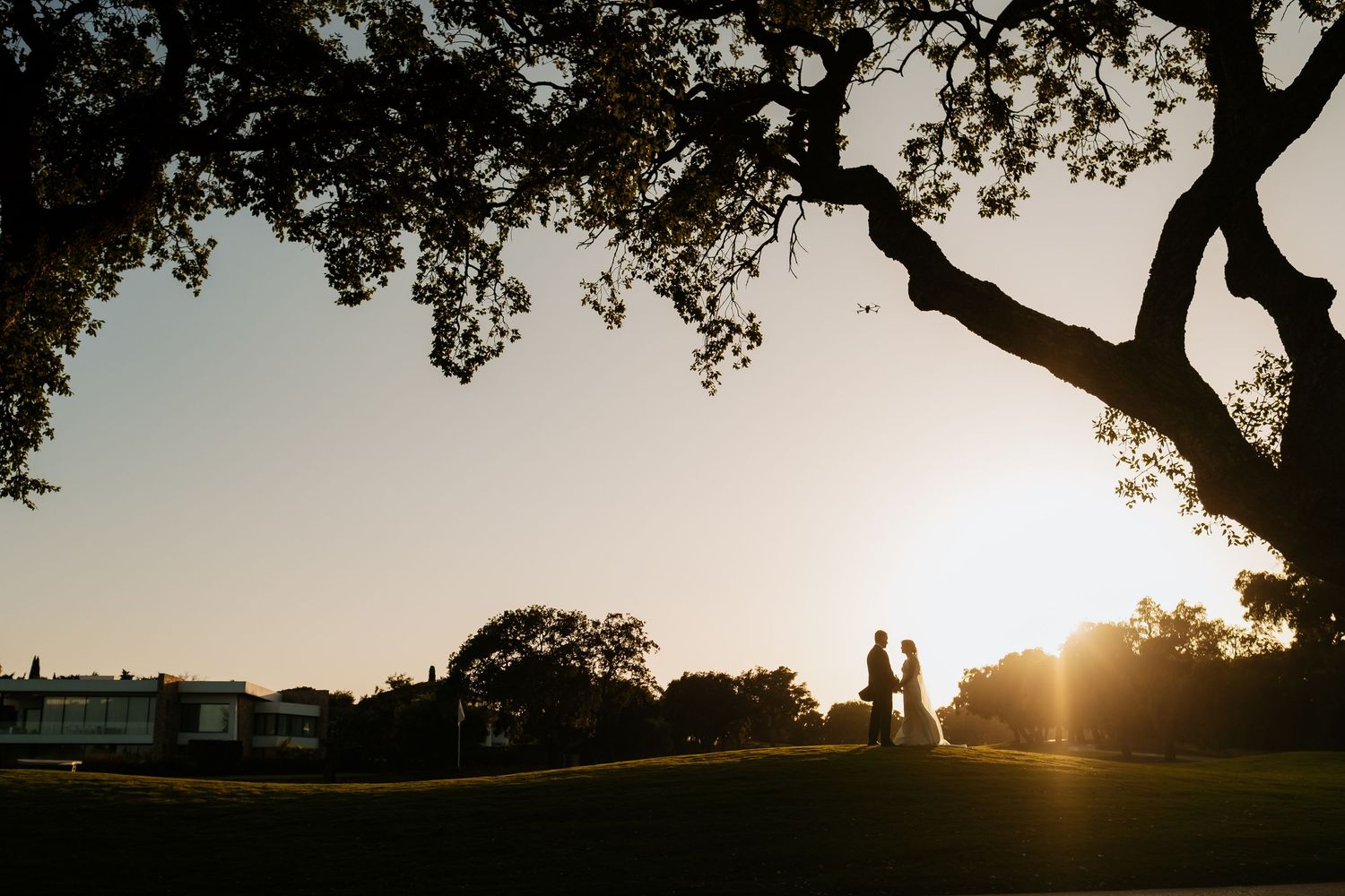 Fotógrafo de bodas de lujo en Sotogrande: pareja en campo de golf durante sesión de fotos al atardecer en Cádiz