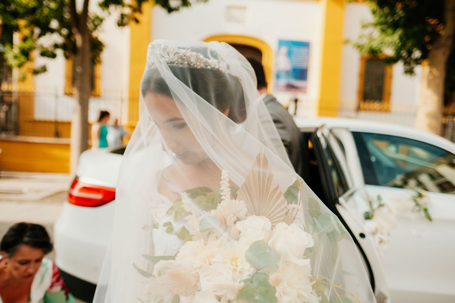 María, velada y saliendo del coche nupcial