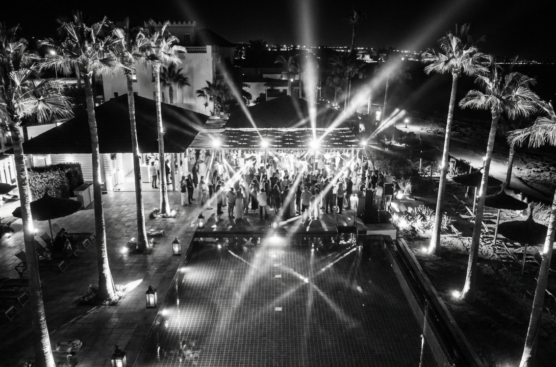 Foto en blanco y negro de la fiesta con luces en la piscina