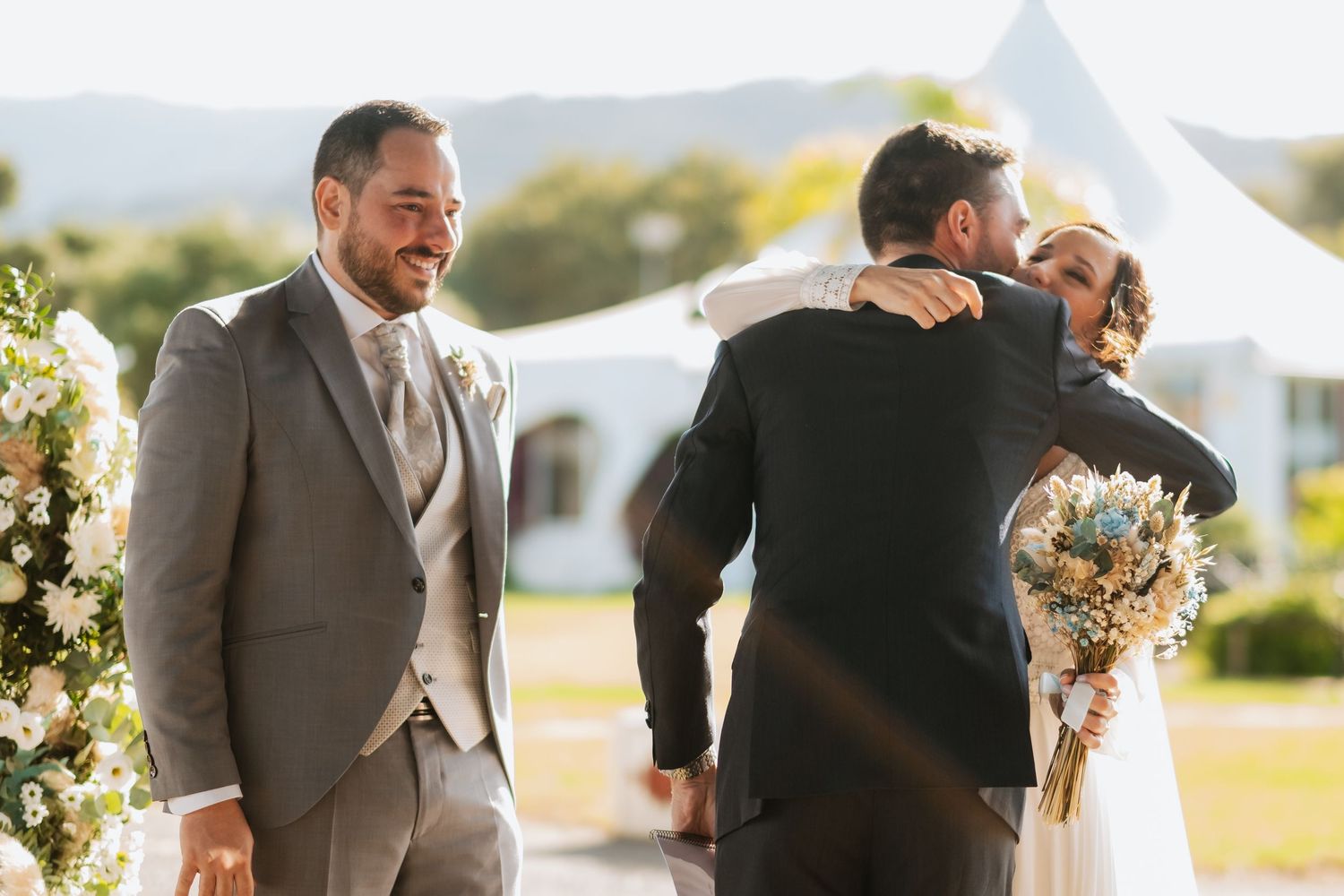 Wedding guests sharing emotional embraces during outdoor ceremony, Roberto Pecino fotografo en Soto de Roma