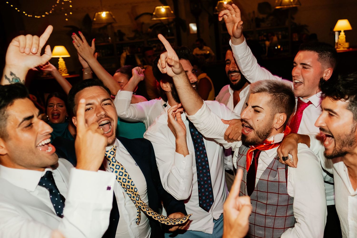 Invitados en modo festivo cantando en el salón del banquete