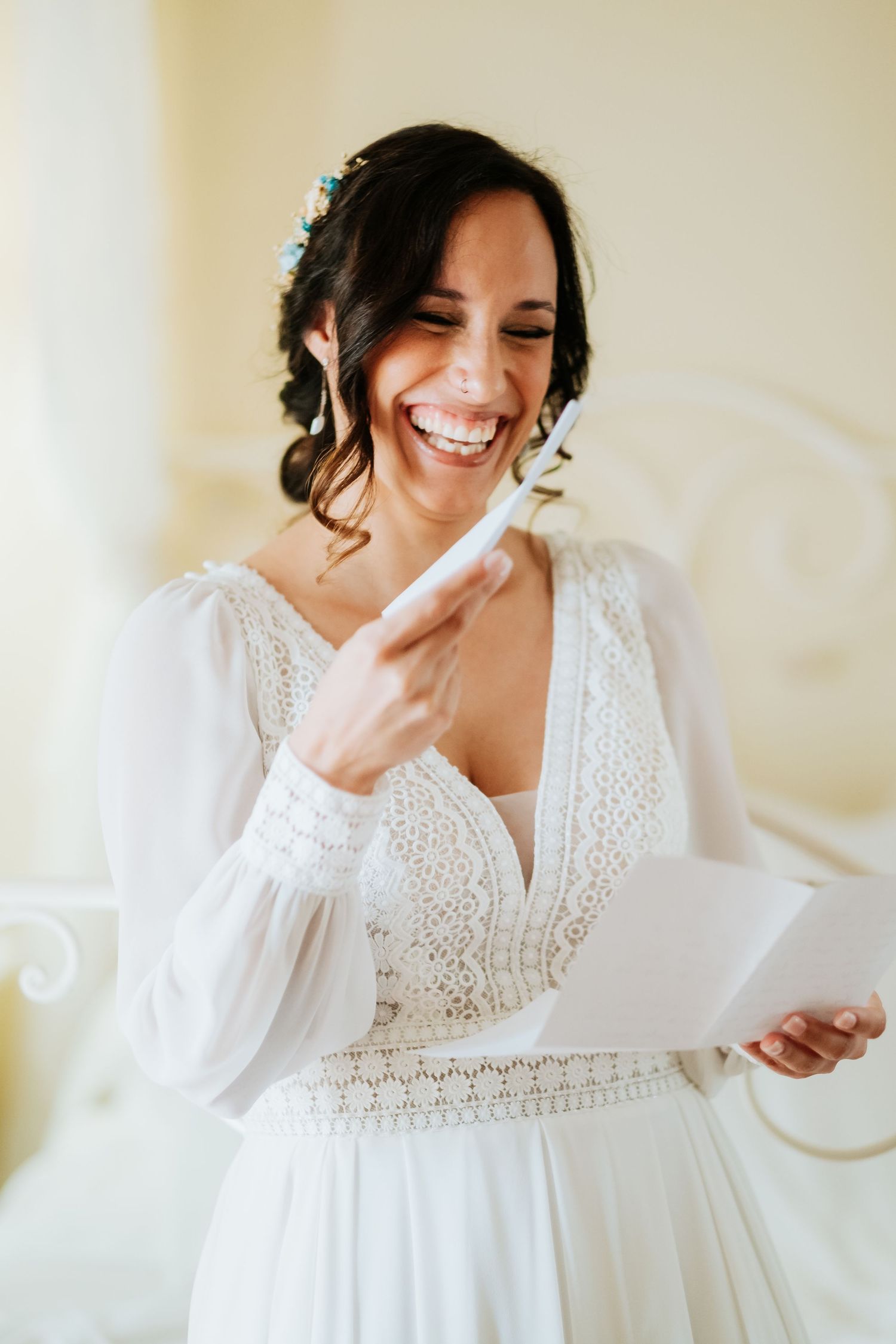 A person in a white lace dress reading a letter with emotional expressions.