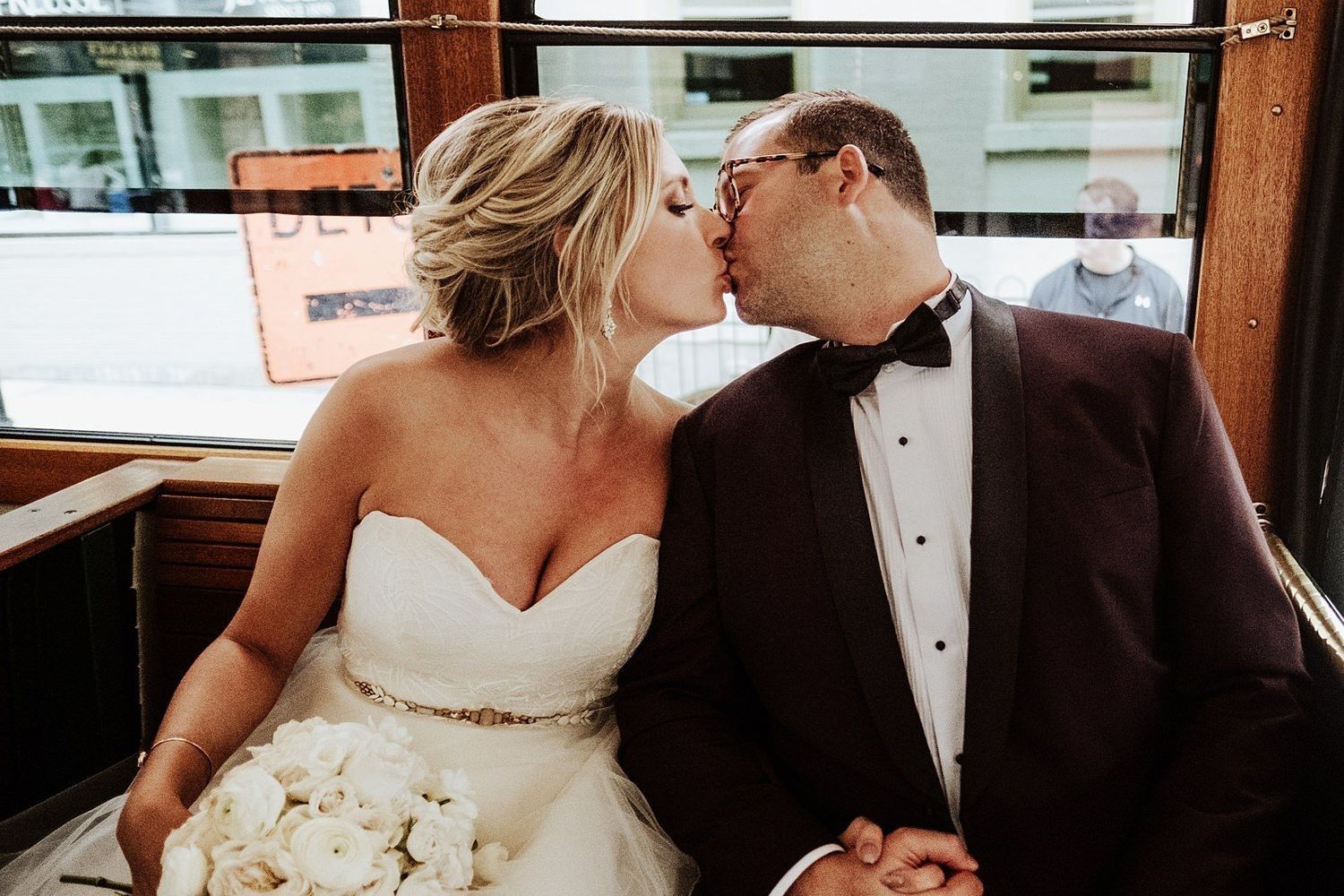Shannon and Karel sharing a romantic kiss inside the vintage wedding Trolley in Michigan.