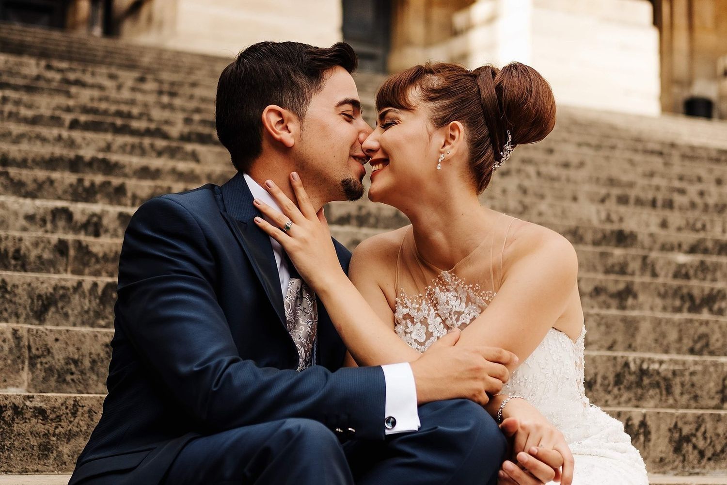 marisa y cristian con gesto cariñoso en las escaleras del palacio de justicia de paris con elegancia atemporal