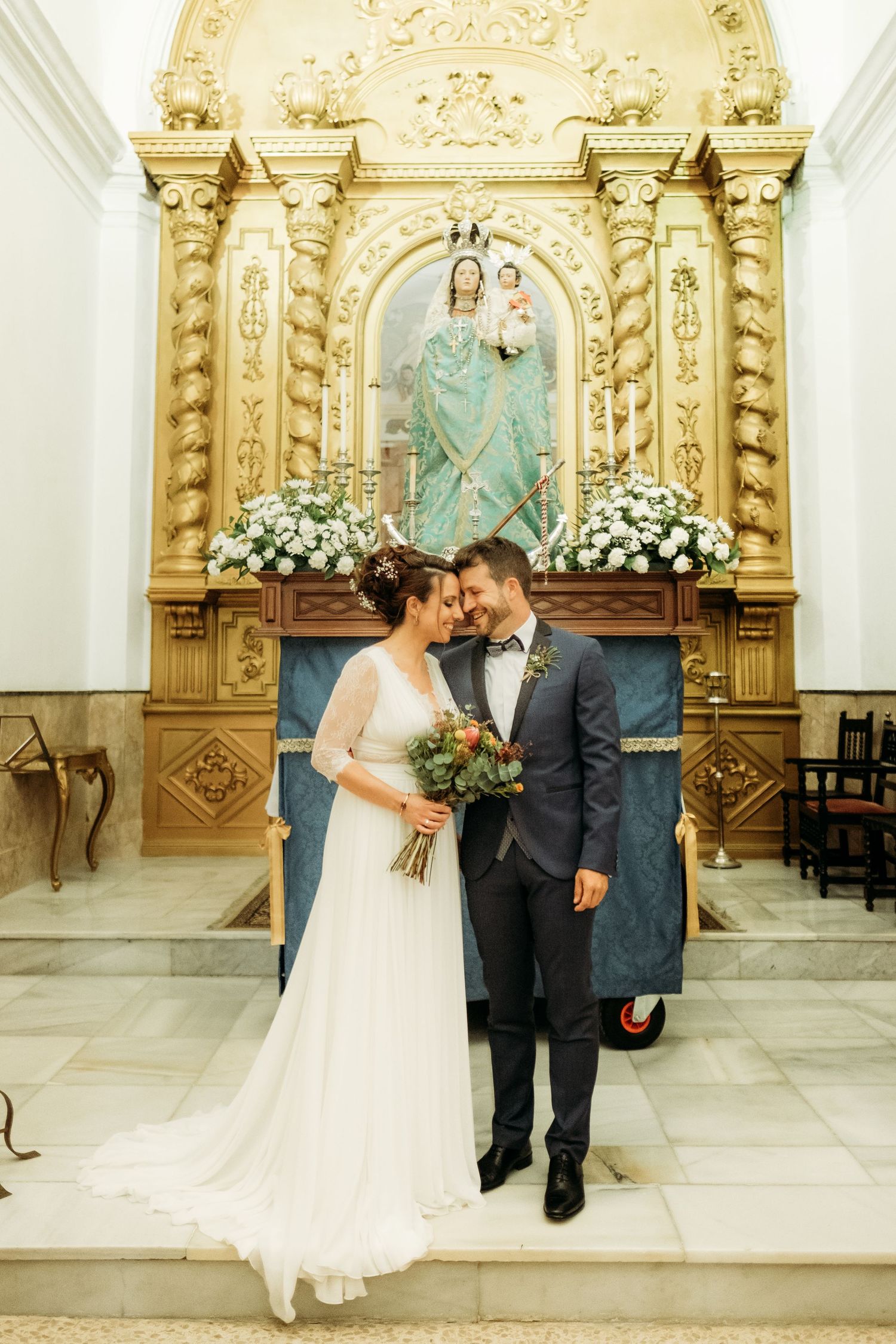 Novios posando delante de la Virgen de La Luz de Tarifa