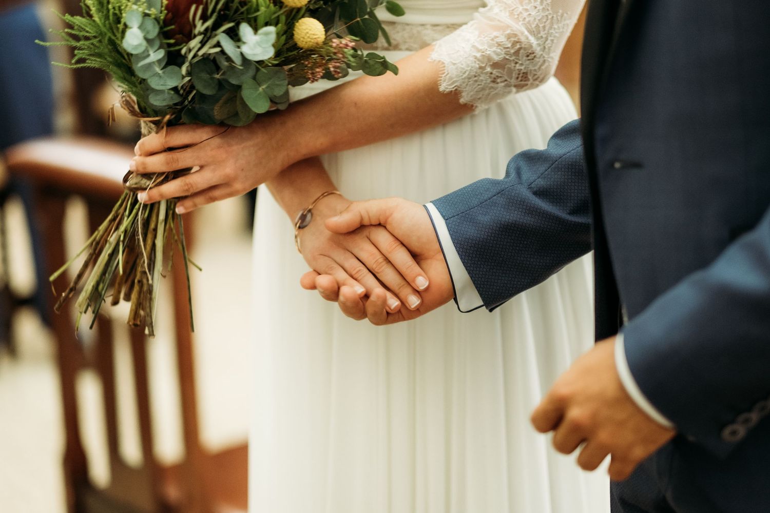 Detalle de las manos de los novios en su boda en la Iglesia