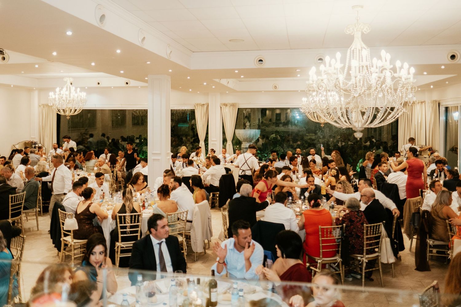 Invitados sentados disfrutando del banquete nupcial en el salón