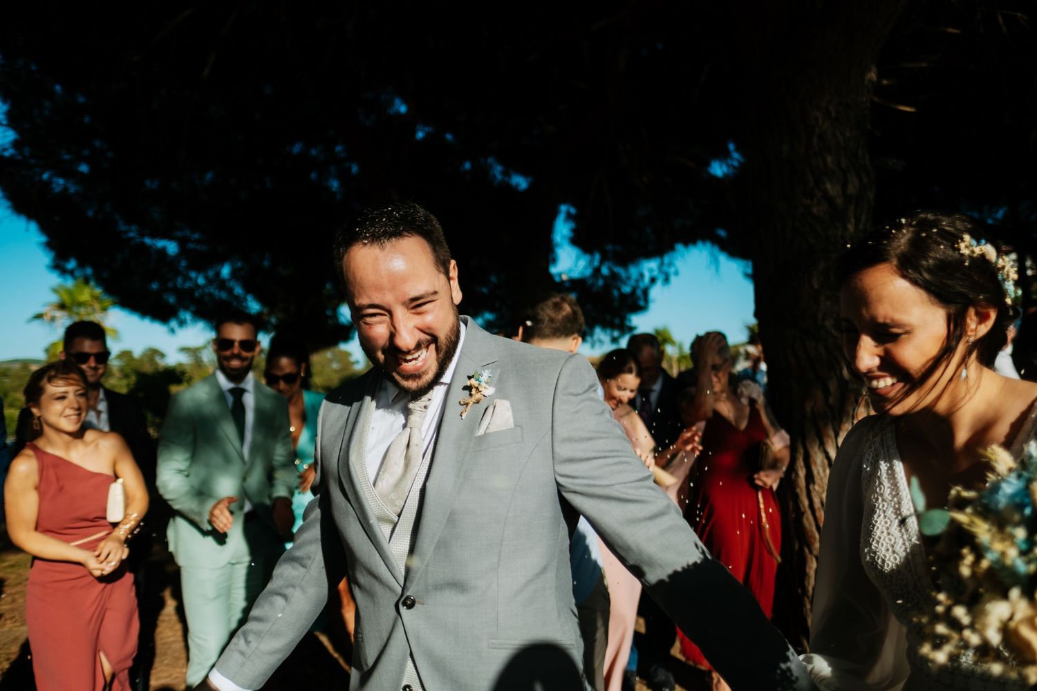 Wedding party celebrating outdoors on a sunny day with natural decor and landscaping, Soto de Roma