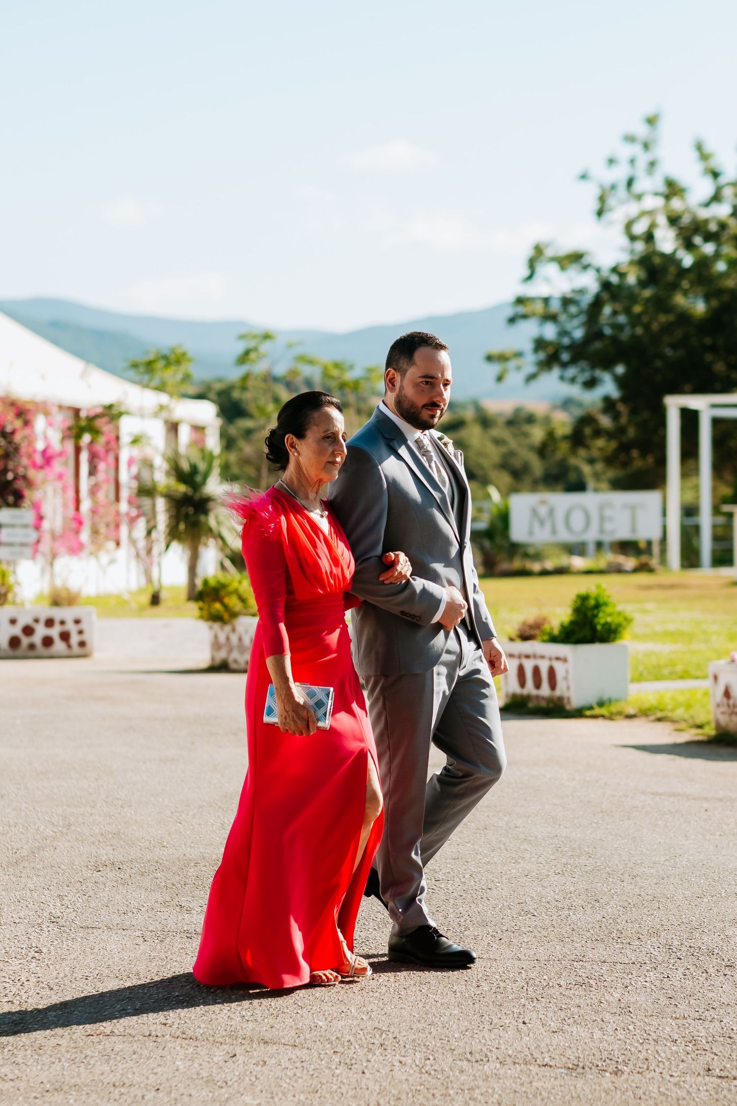 A couple poses playfully in a series of outdoor photos, with the person in a vibrant red dress against a scenic backdrop.
