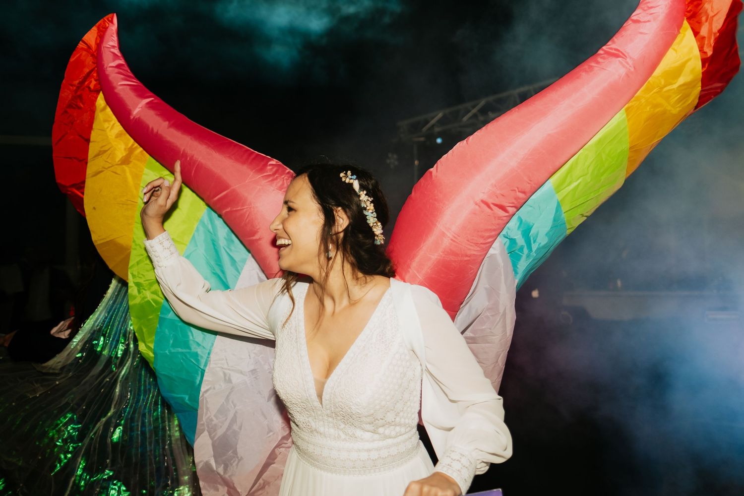 Colorful rainbow flag waving during an emotional wedding celebration moment.