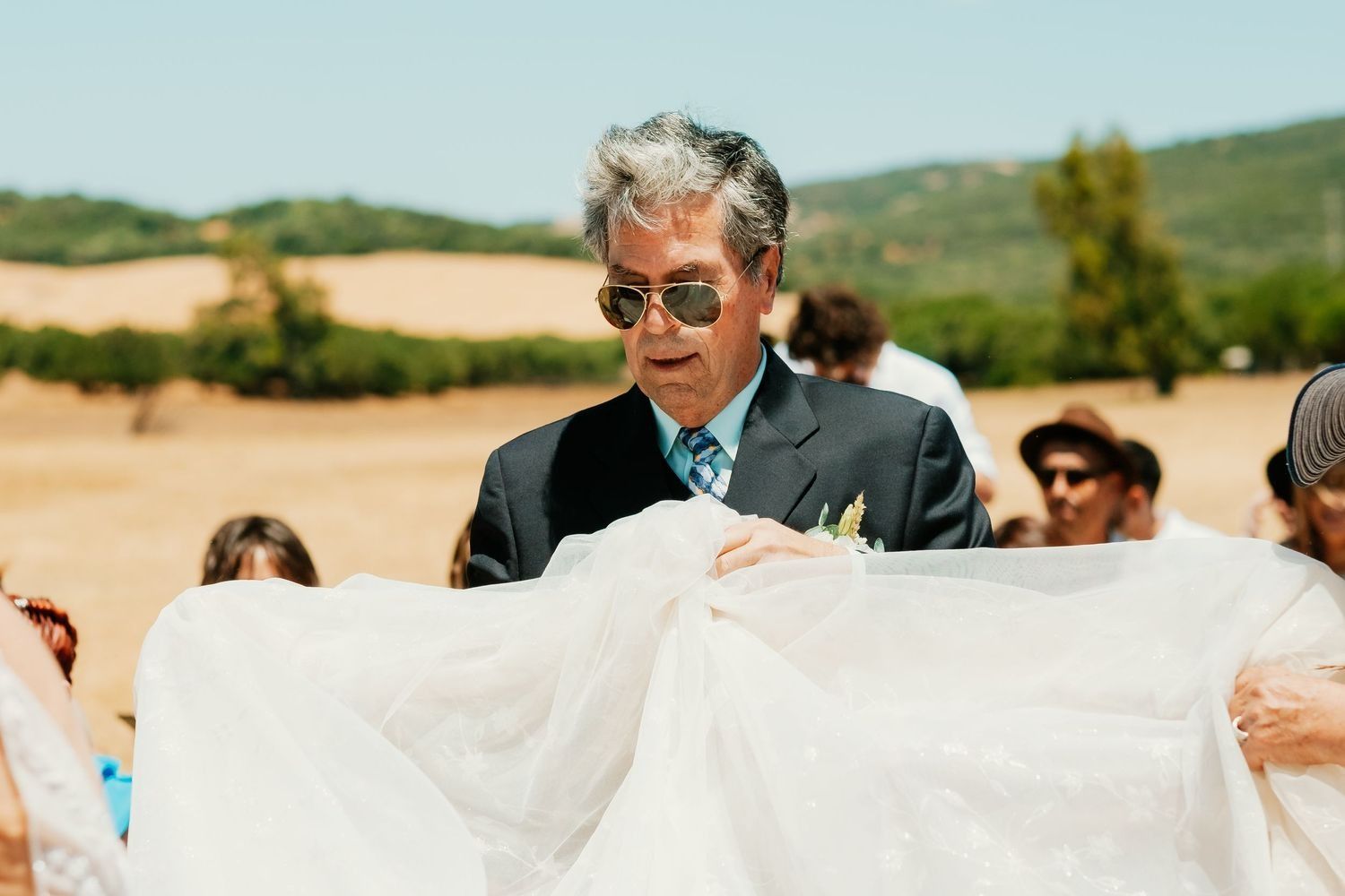 Padrino llevando cola del vestido de la novia Lorena, Boda en Wakana