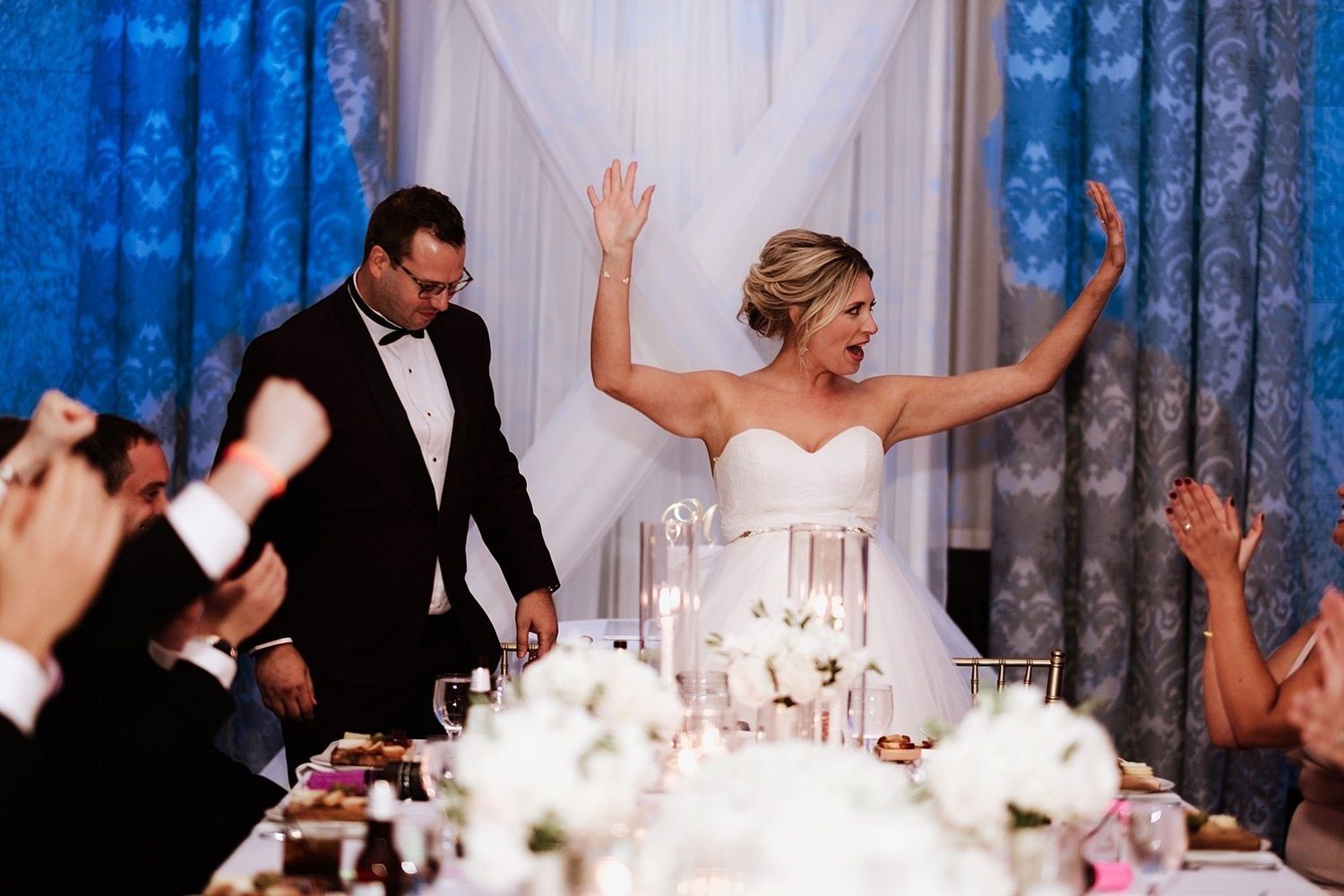 Panoramic view of the wedding reception: Shannon celebrating among luxury table settings and floral centerpieces
