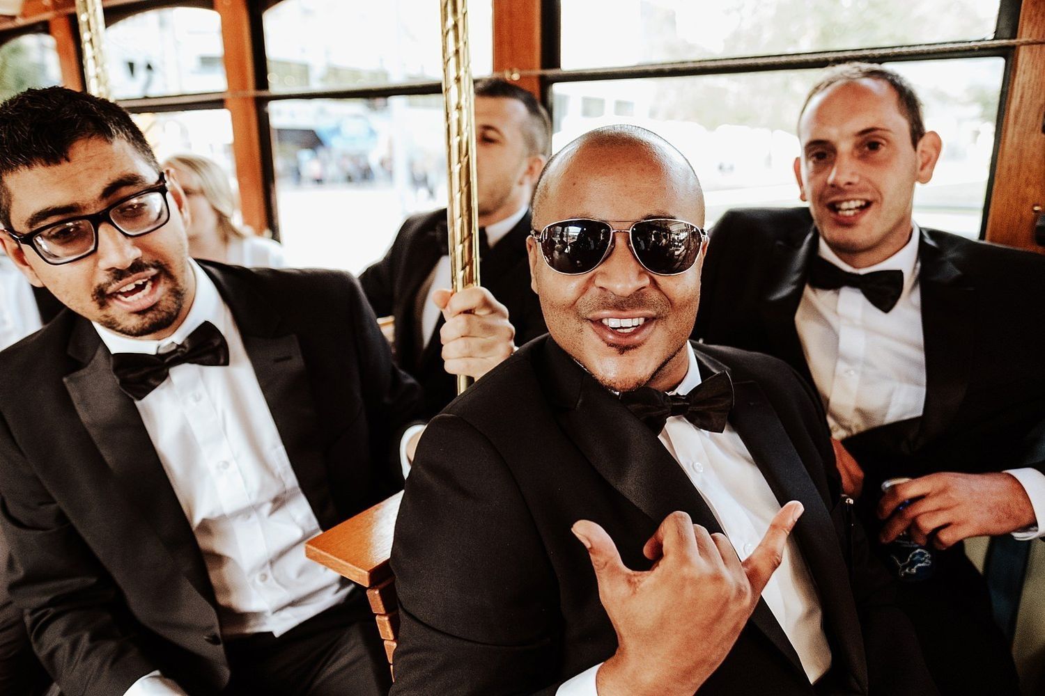 Karel’s groomsmen celebrating and cheering inside the Grand Rapids Trolley