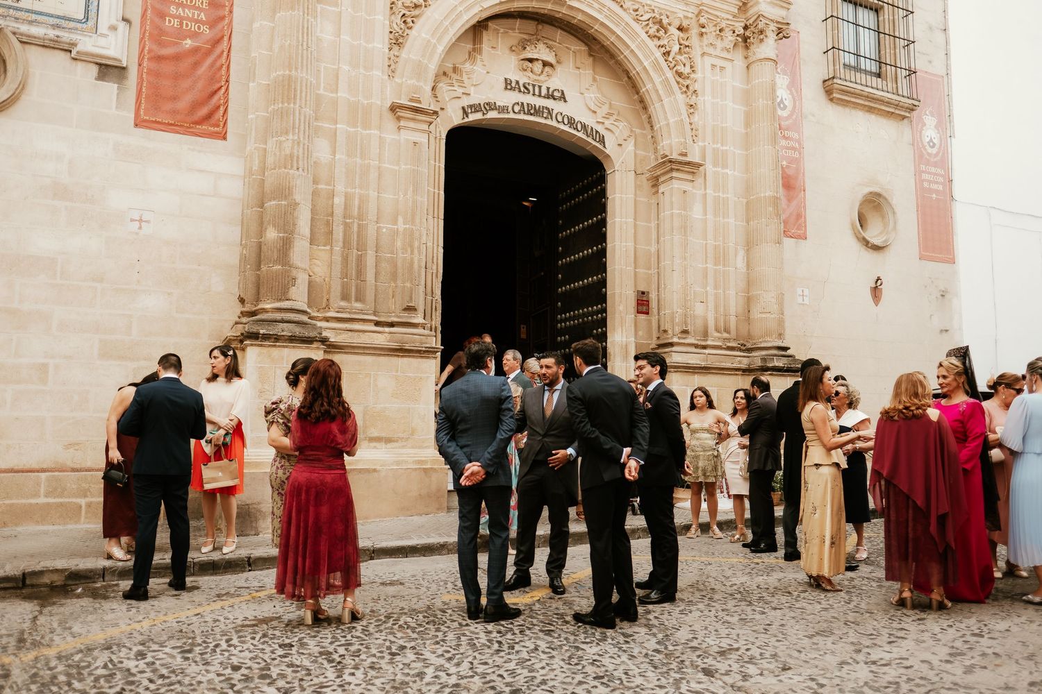 Invitados de boda reunidos ante la fachada histórica de la Basílica del Carmen en Jerez, Roberto Pecino Fotógrafo