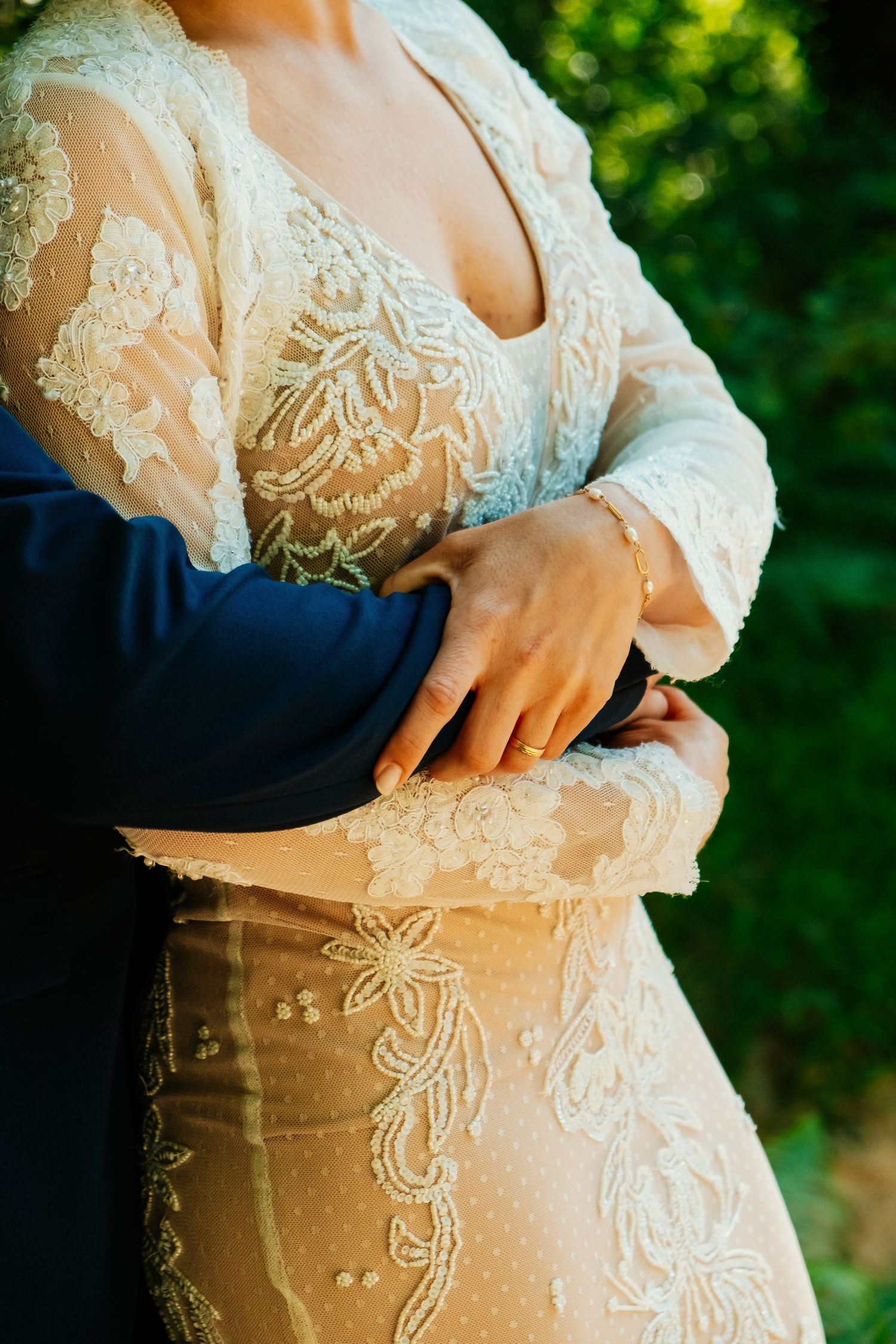 Primer plano del abrazo de Alejandra y Jose con detalle del encaje del vestido de novia, postboda en San Roque