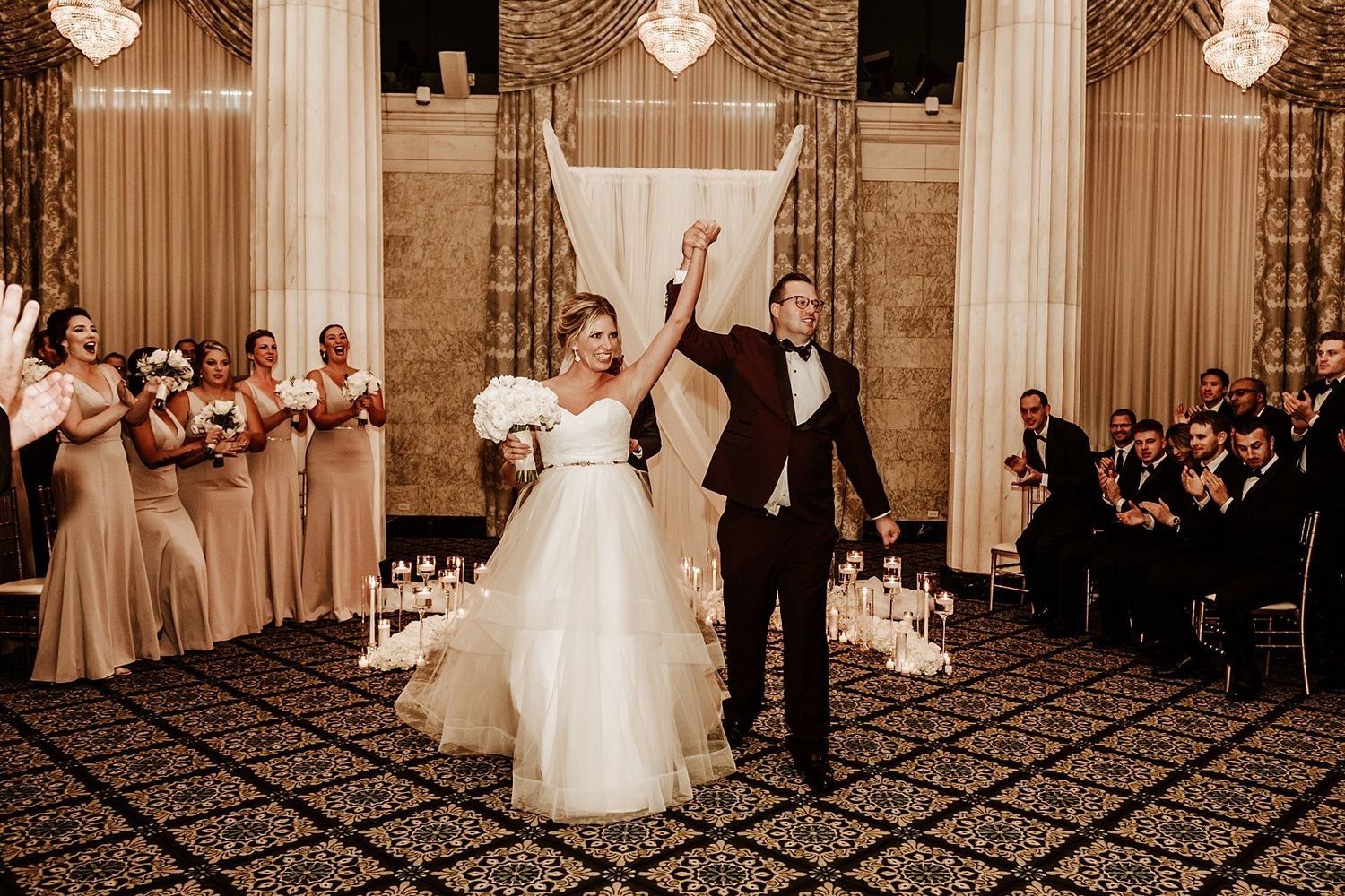 Shannon and Karel celebrating their marriage while walking down the aisle at McKay Ballroom