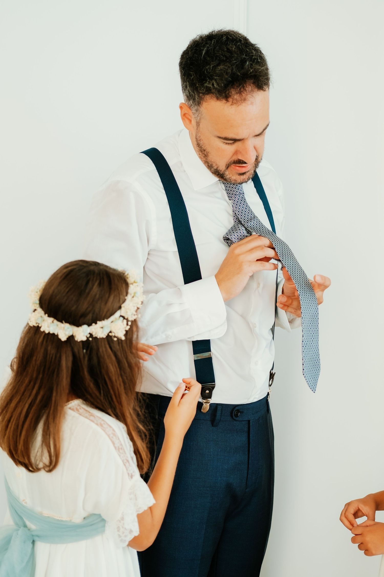 Hija del novio ayudando a su padre a vestirse antes de la ceremonia en el Baluarte