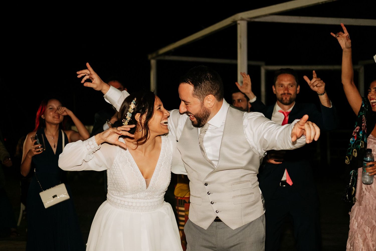 Wedding reception dance party with guests celebrating on a dark dance floor.