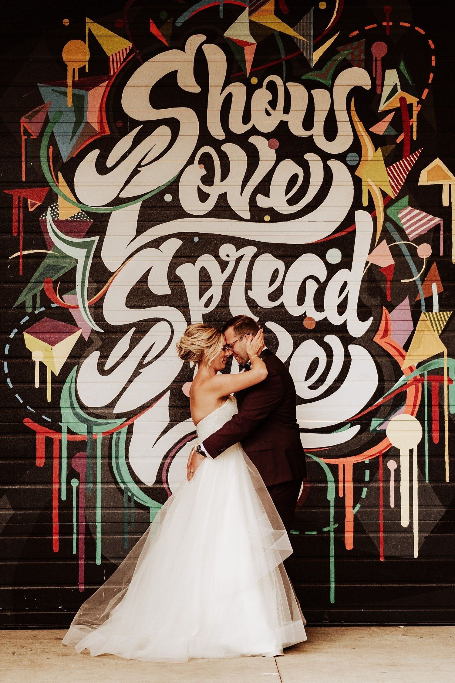 Bride and groom posing in front of an iconic and famous graffiti mural in Michigan