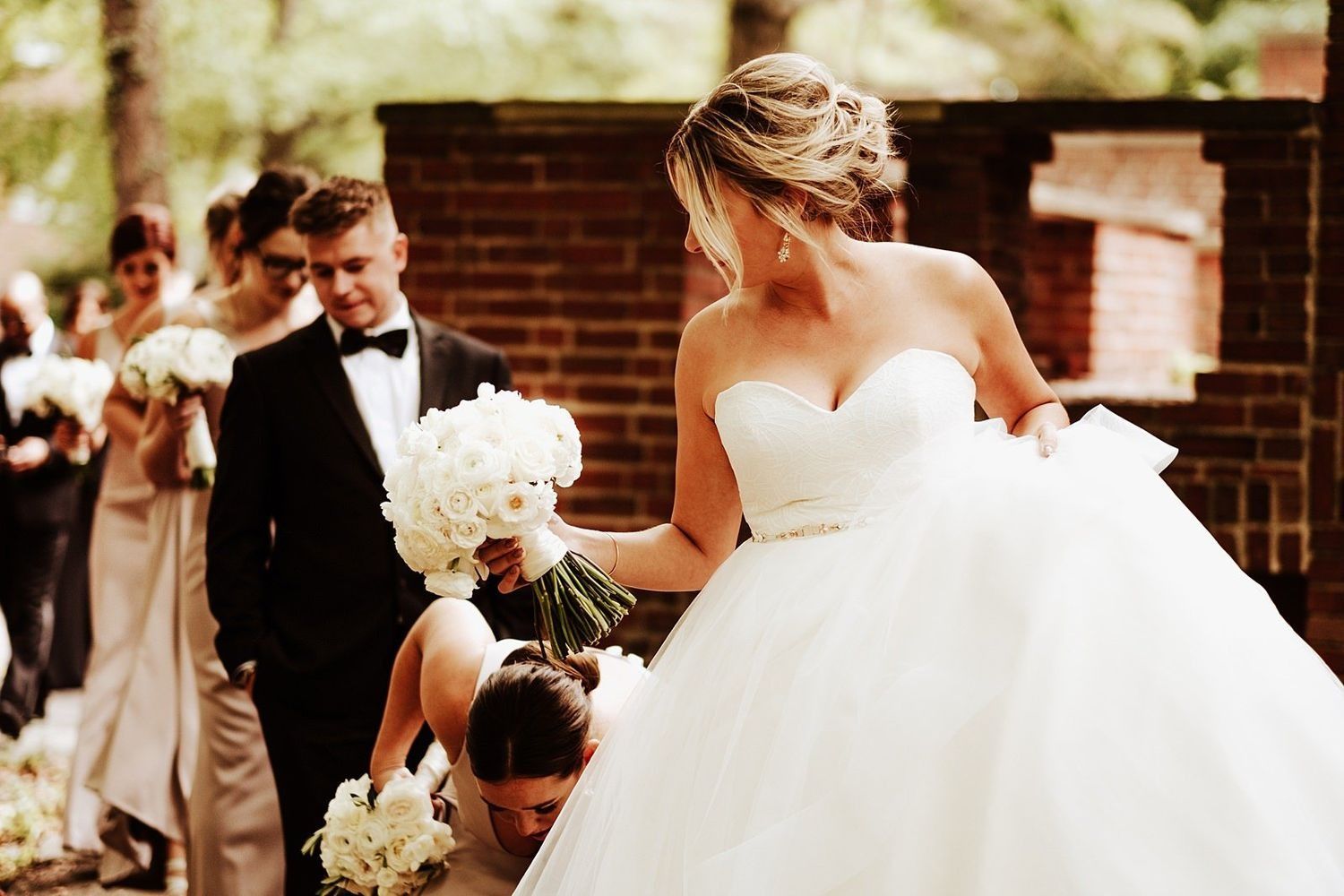 Natural bridal portrait: Shannon walking through Grand Rapids holding her dress and bouquet
