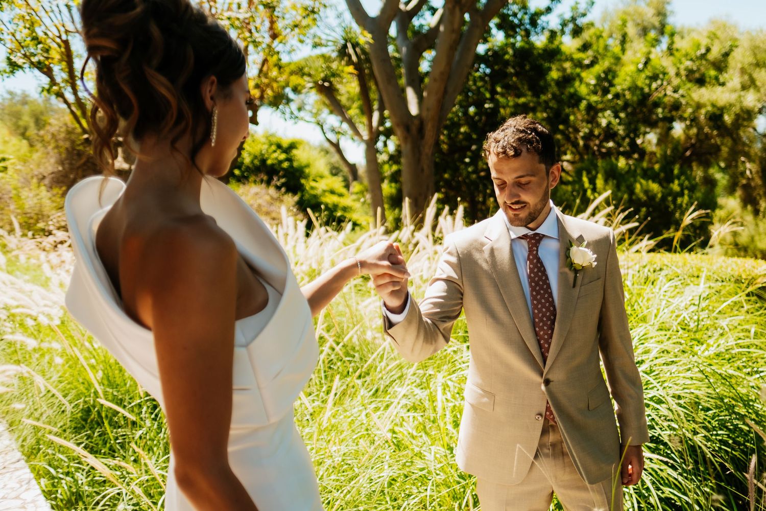 Couple shares romantic moments in a lush garden setting with natural sunlight filtering through trees. Photographer in Gibraltar