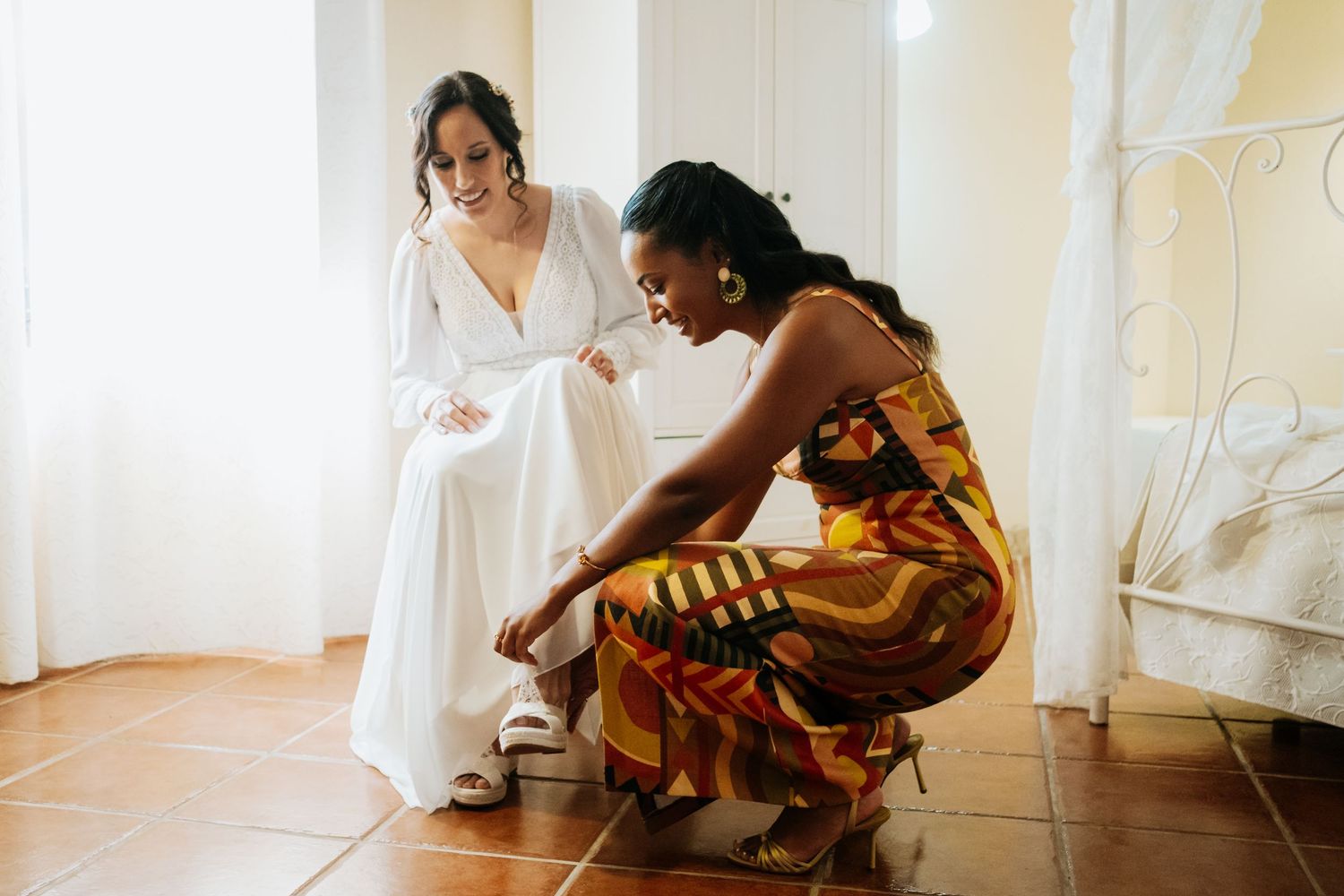 Lidia vistiéndose de novia con ayuda de su amiga en Los Barrios - Fotografía emotiva