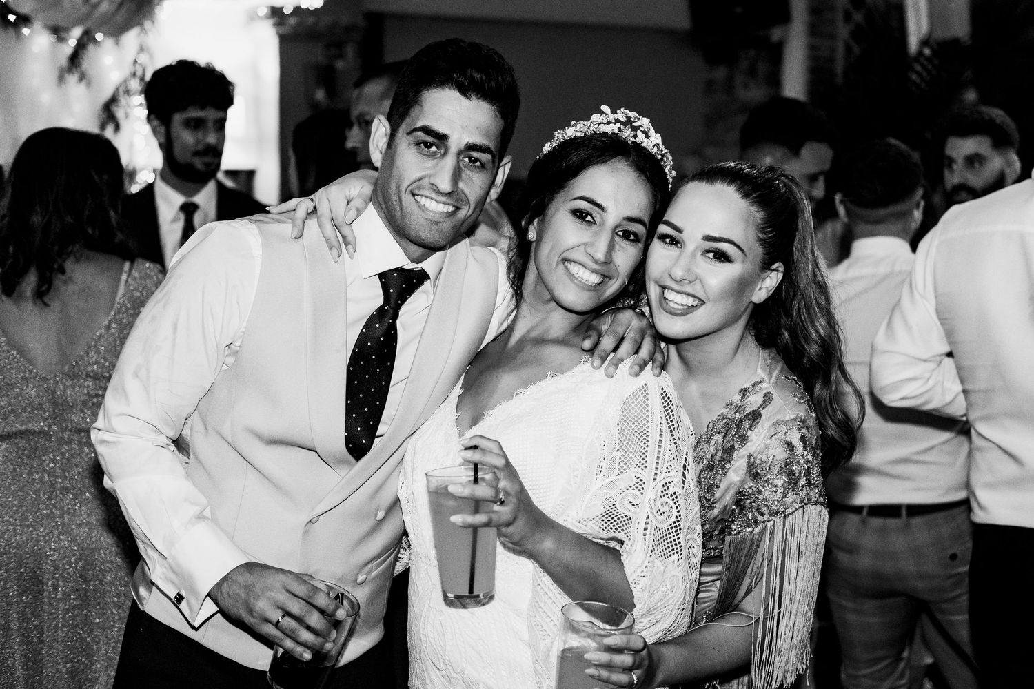 El novio posando con la novia en El Coto, los invitados tambien están presente en mis reportajes de boda