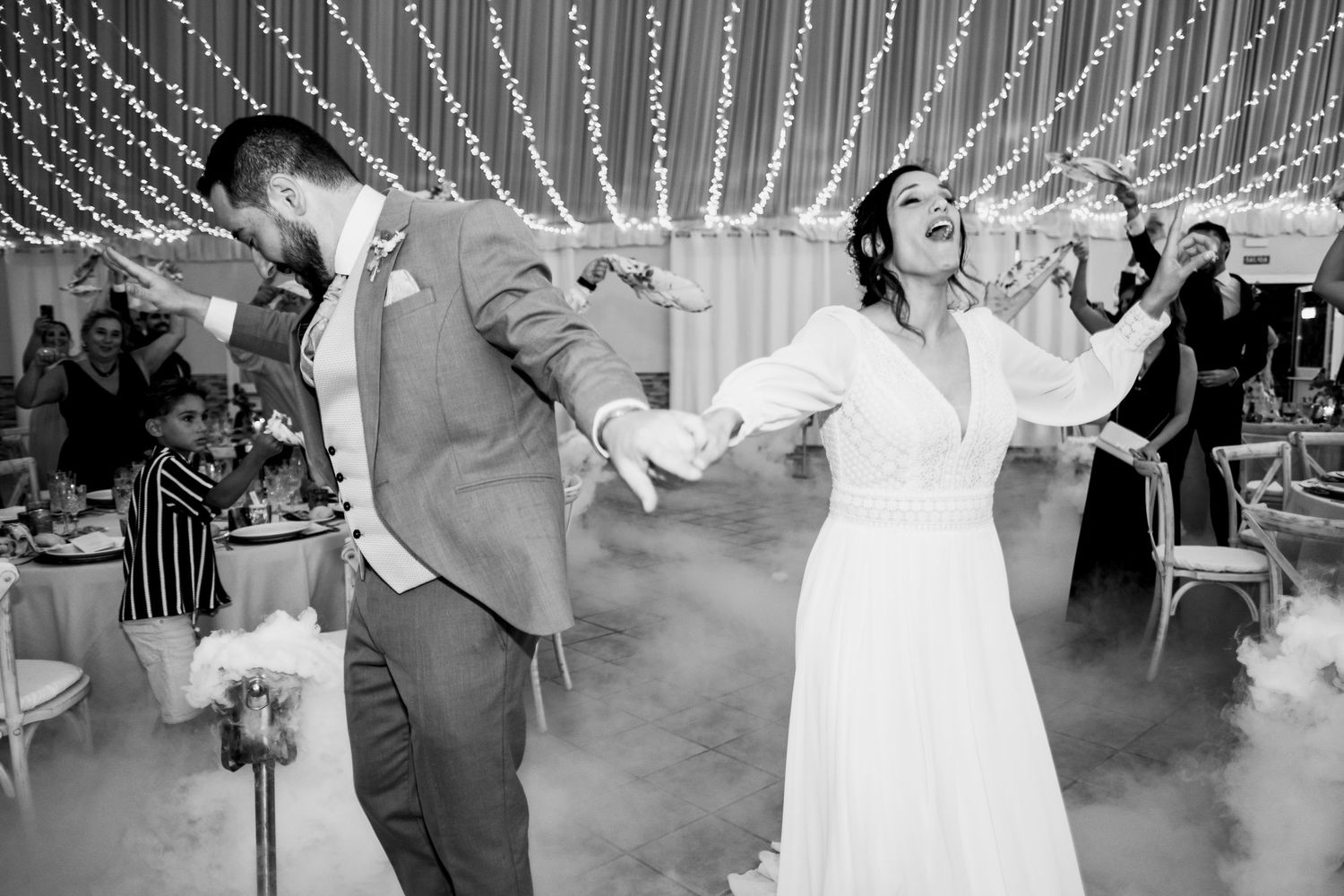 Wedding reception dance floor with string lights creating a magical atmosphere overhead.