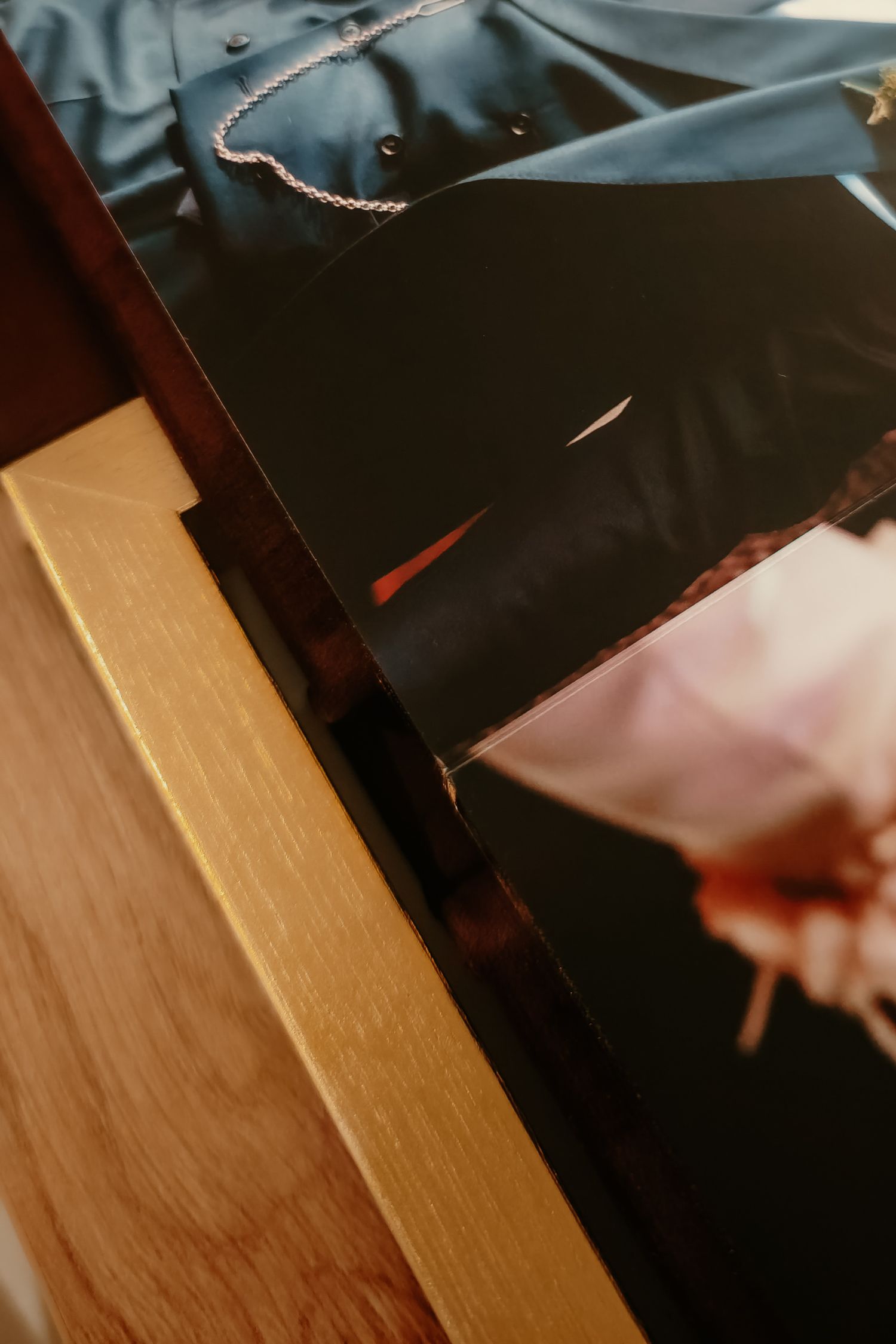 Close-up view of a black shopping bag against a wooden surface in soft lighting.
