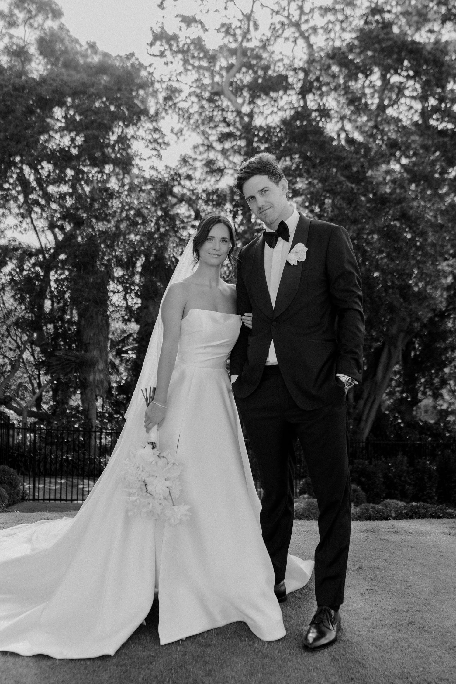 Classic black and white wedding portrait in a garden setting.