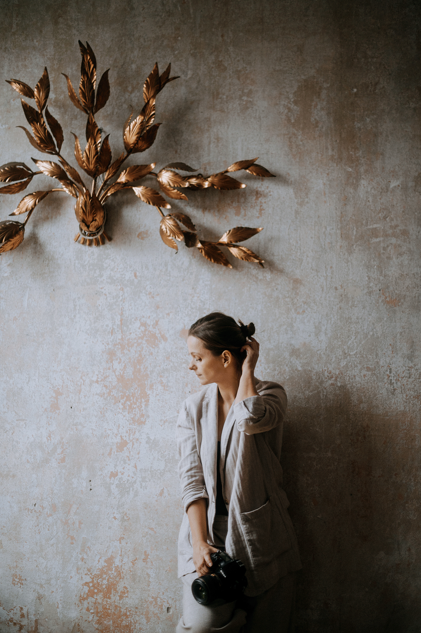 Artistic photo series showing wooden birds flying across a textured wall with a person in muted tones.