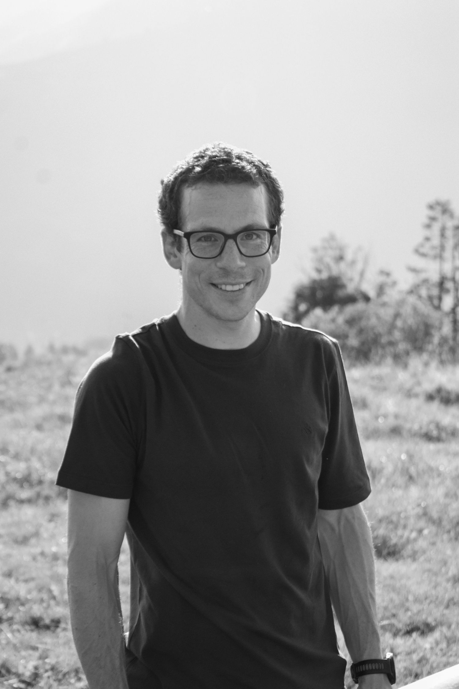 Black and white portrait series of a person wearing glasses and a dark shirt against a light background.