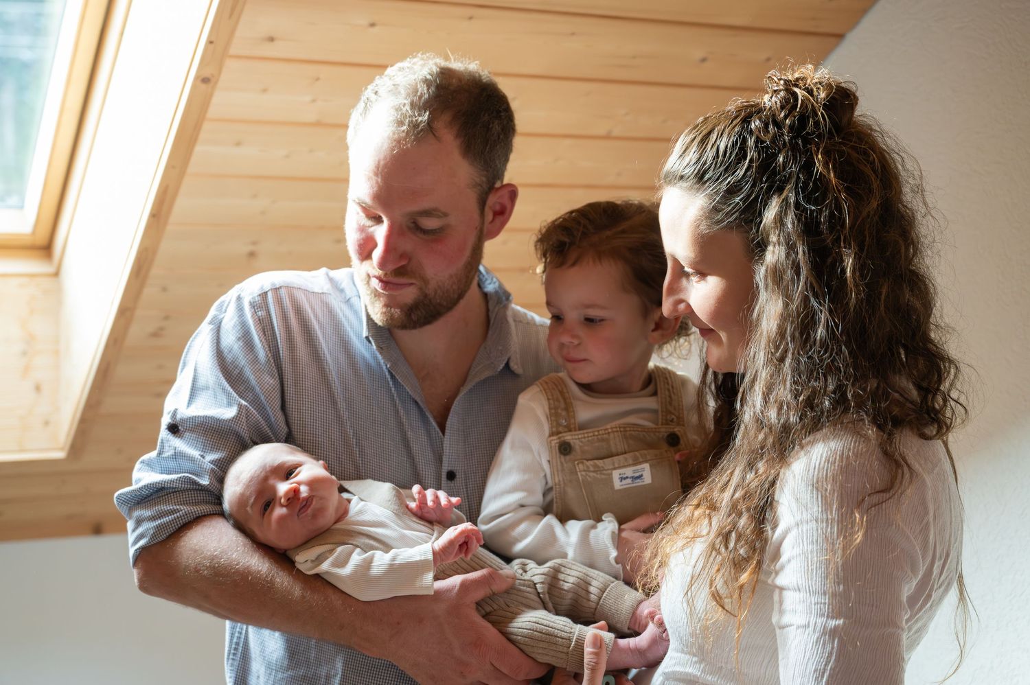 Cozy indoor family moment in a rustic wooden room with natural lighting.