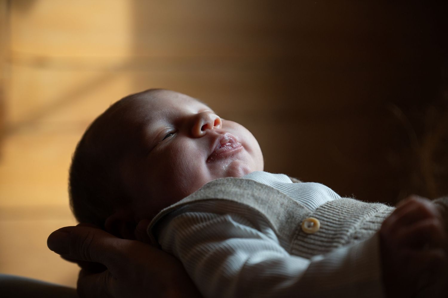 Artistic silhouette of a resting infant in dramatic lighting.