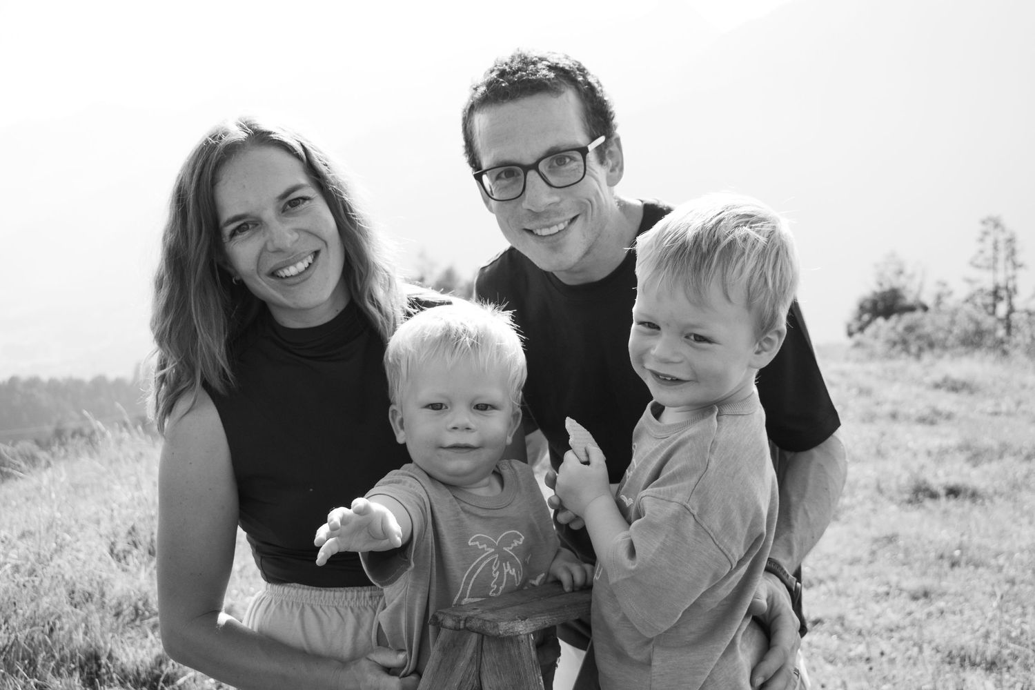 Black and white portrait of a family group on a sunny meadow.