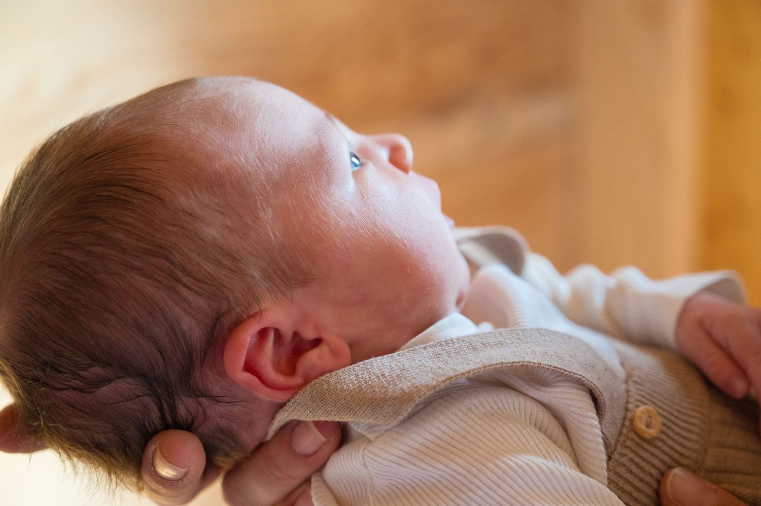 Infant sleeping peacefully on side with natural window light.