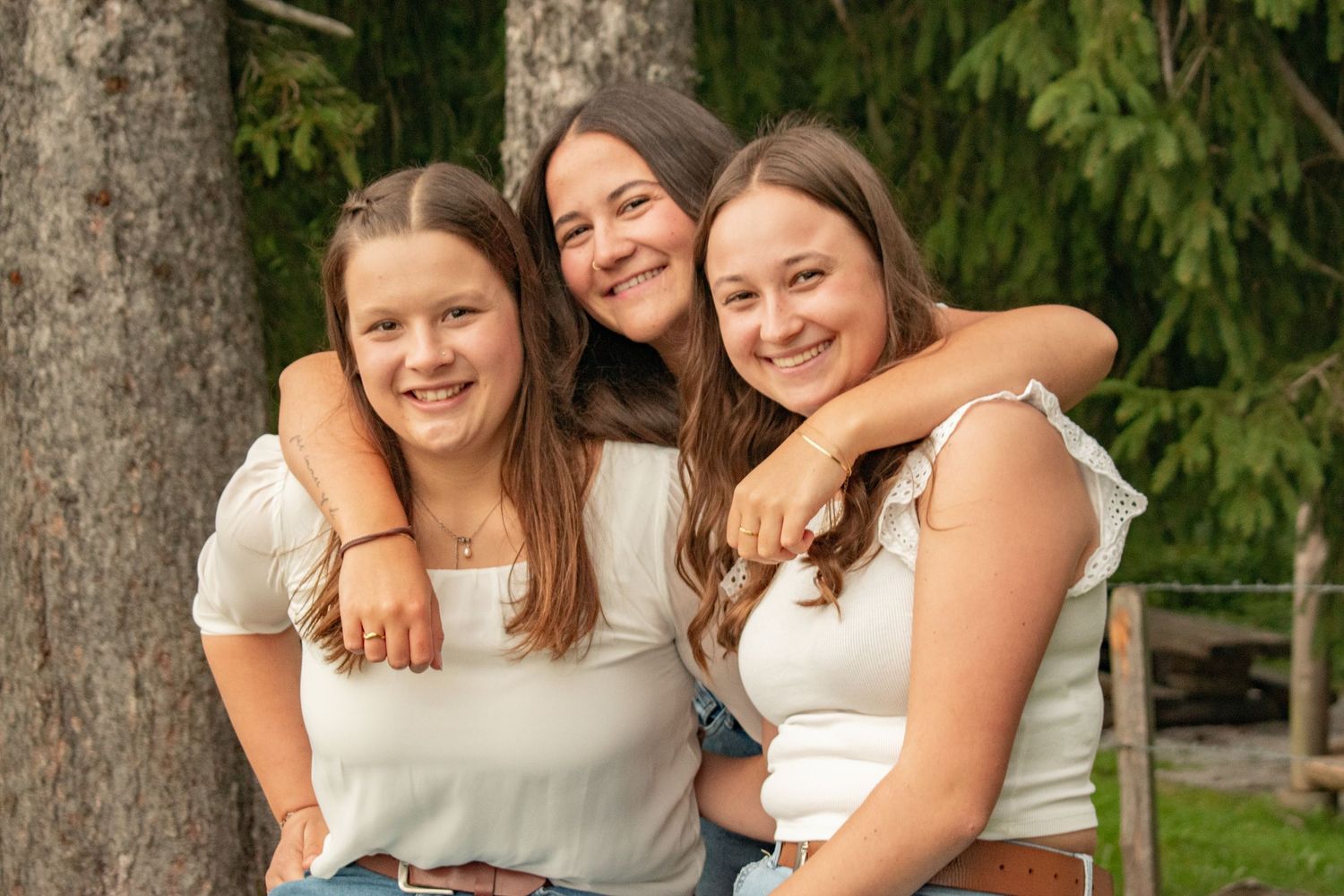Friends sharing joyful moment together outdoors against natural backdrop.