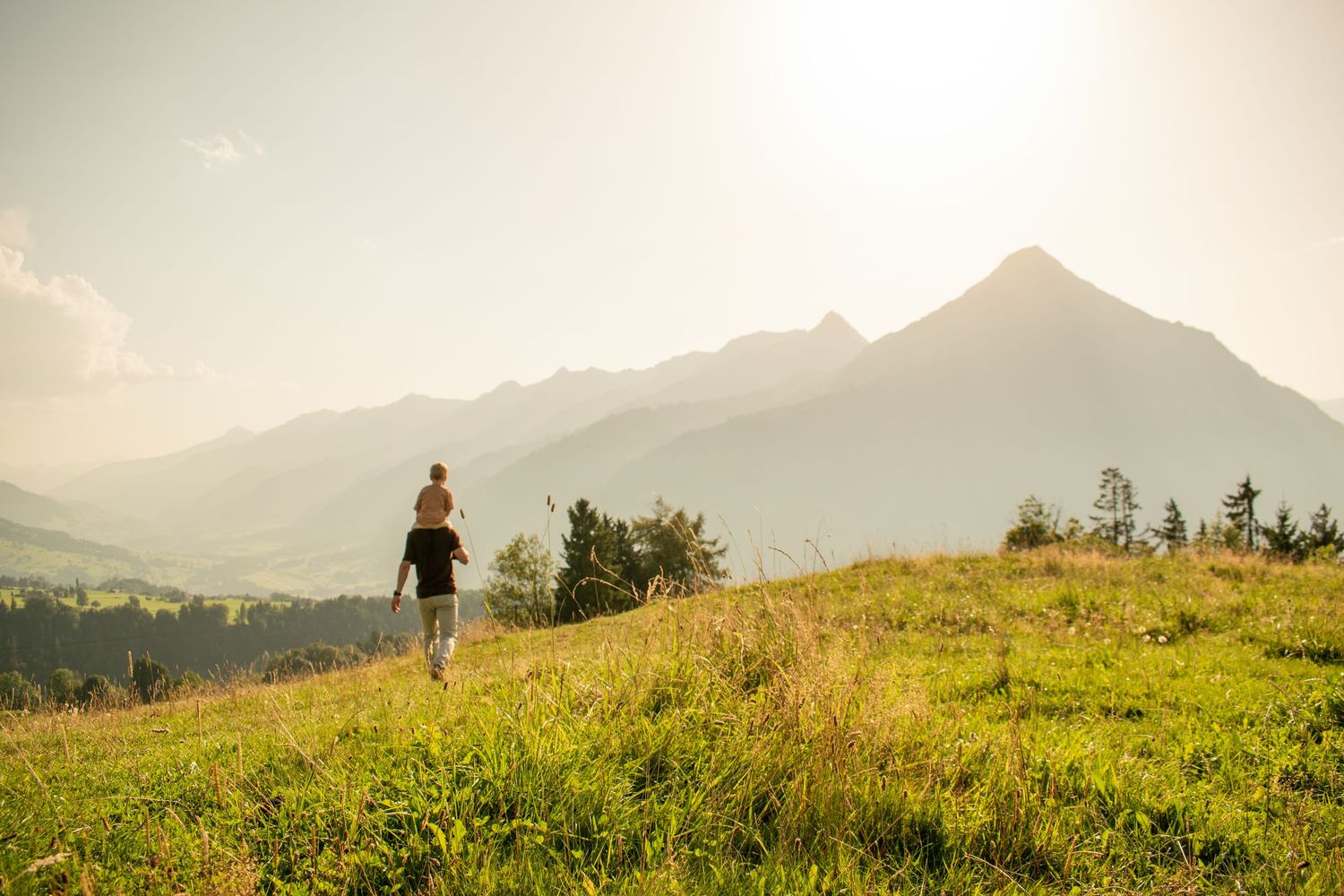Scenic mountain landscape with rolling hills and distant peaks during sunset.