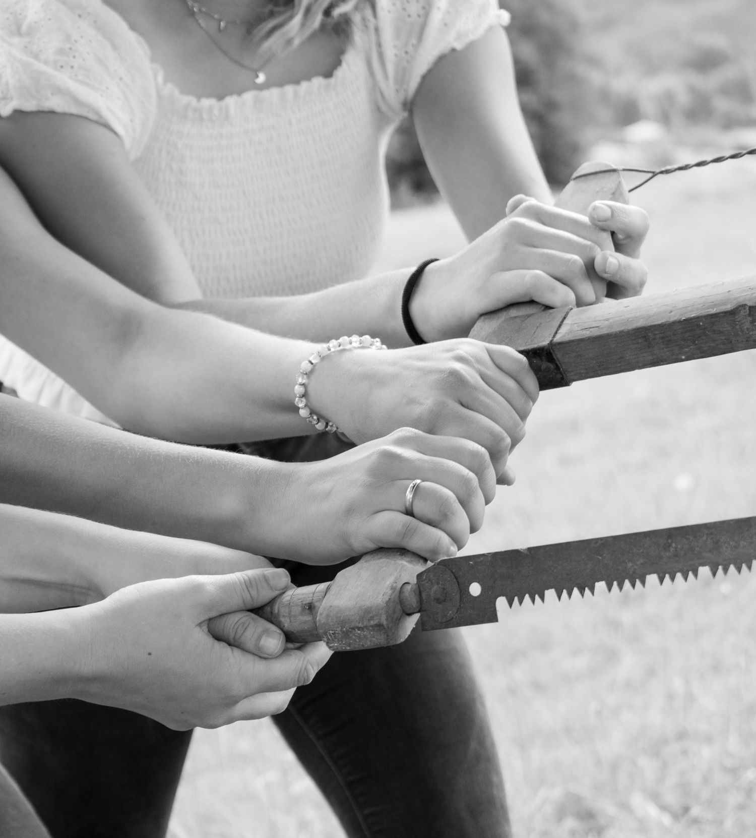 Close-up of hands holding traditional woodworking tools in black and white.