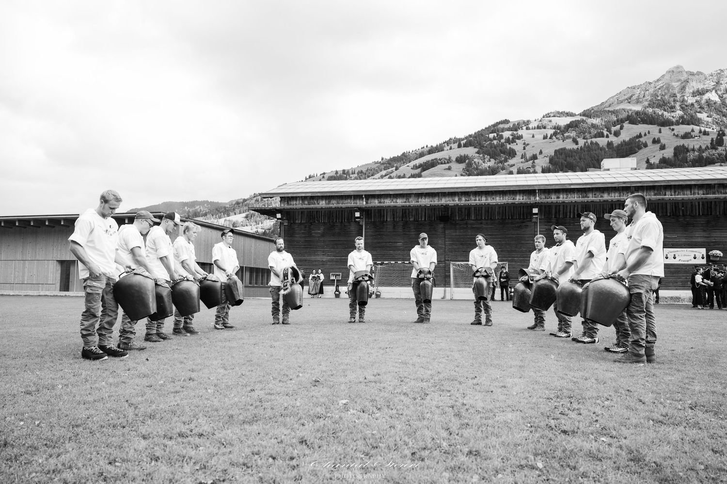 Vintage black and white photograph showing people lined up in rows on a grassy field.