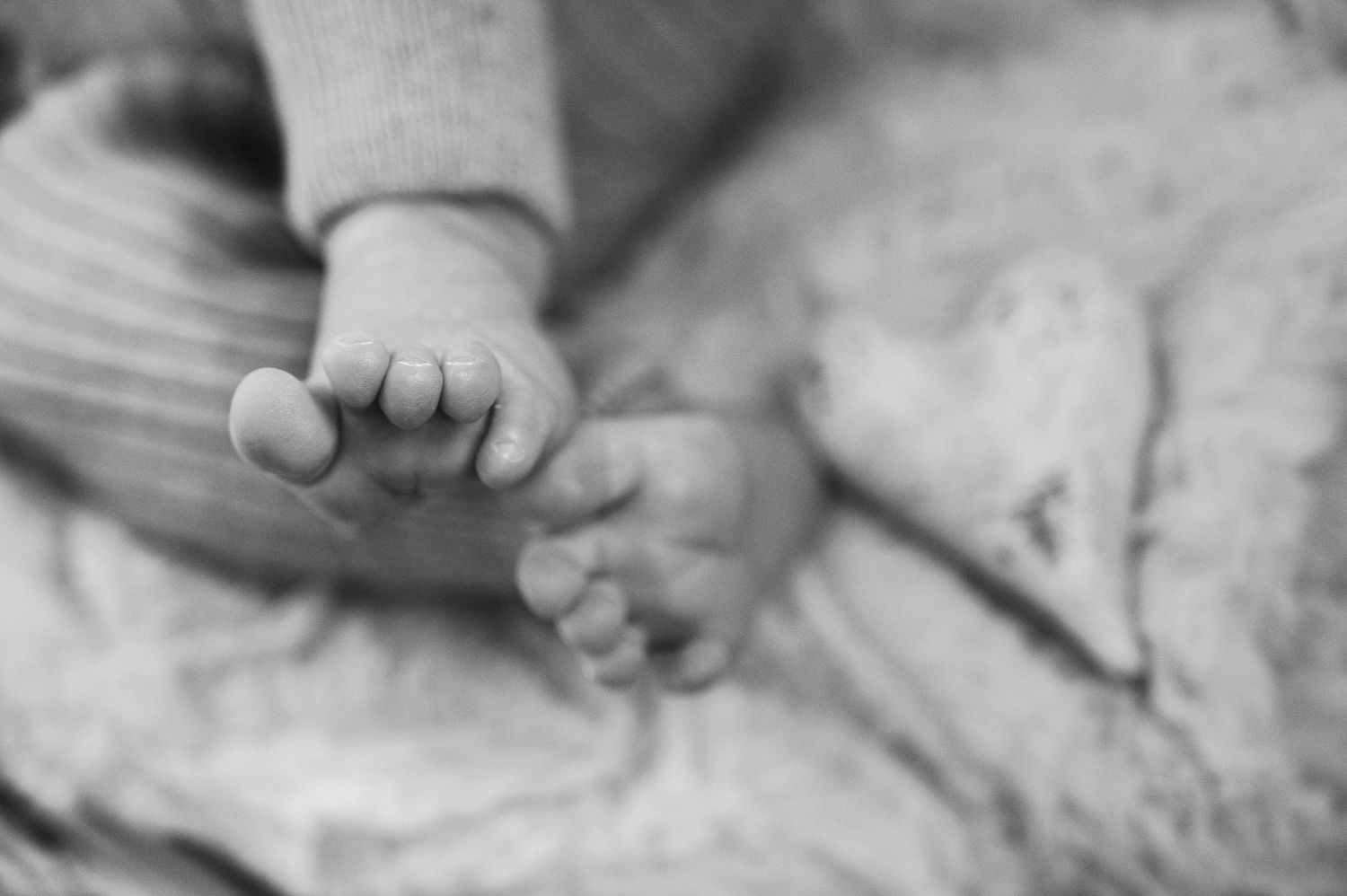 Close-up black and white shots of hands gently touching and intertwining.