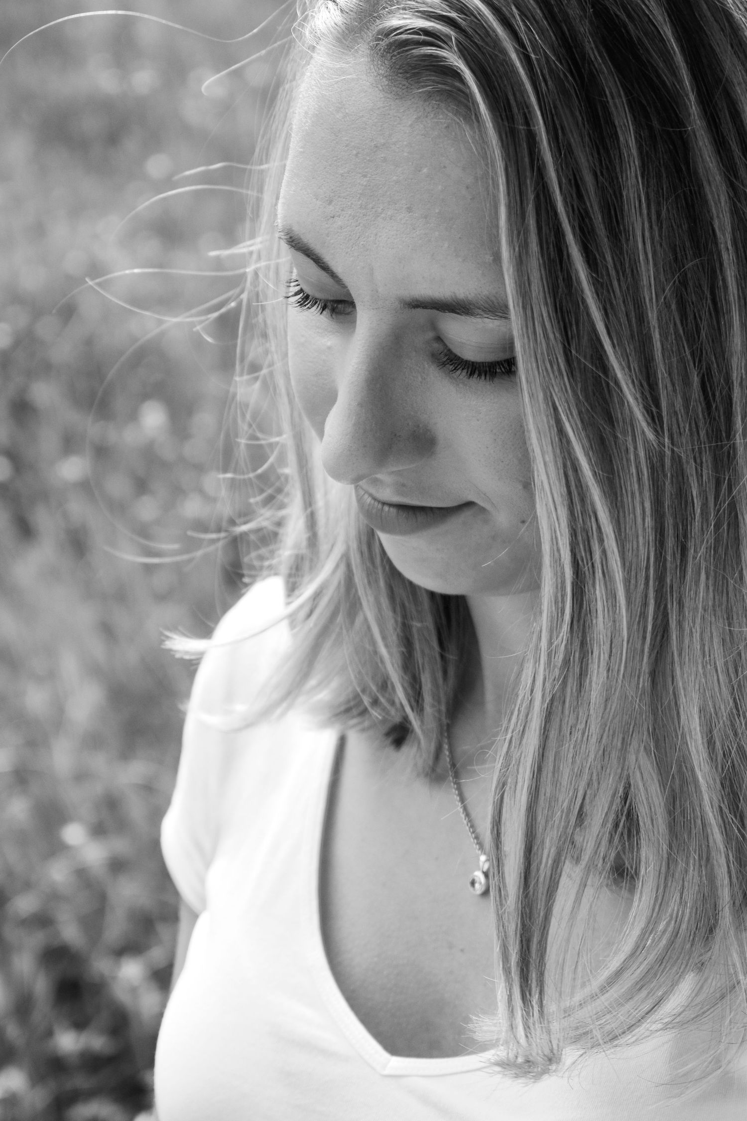 Black and white portrait showing gentle side profile with soft natural lighting.