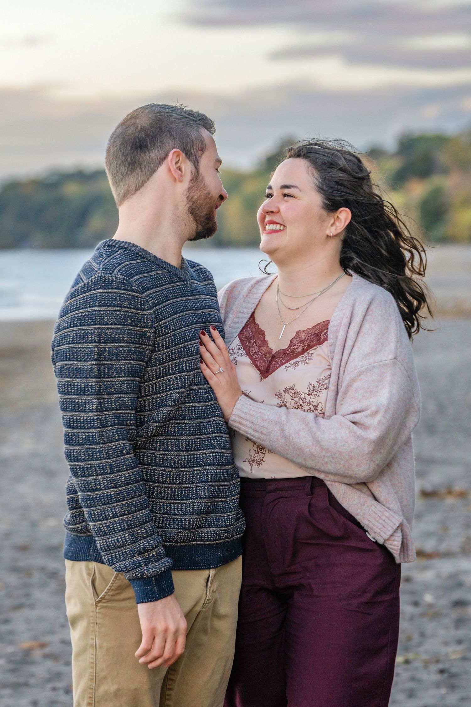 A couple shares a joyful moment together during a romantic beach photoshoot at sunset.