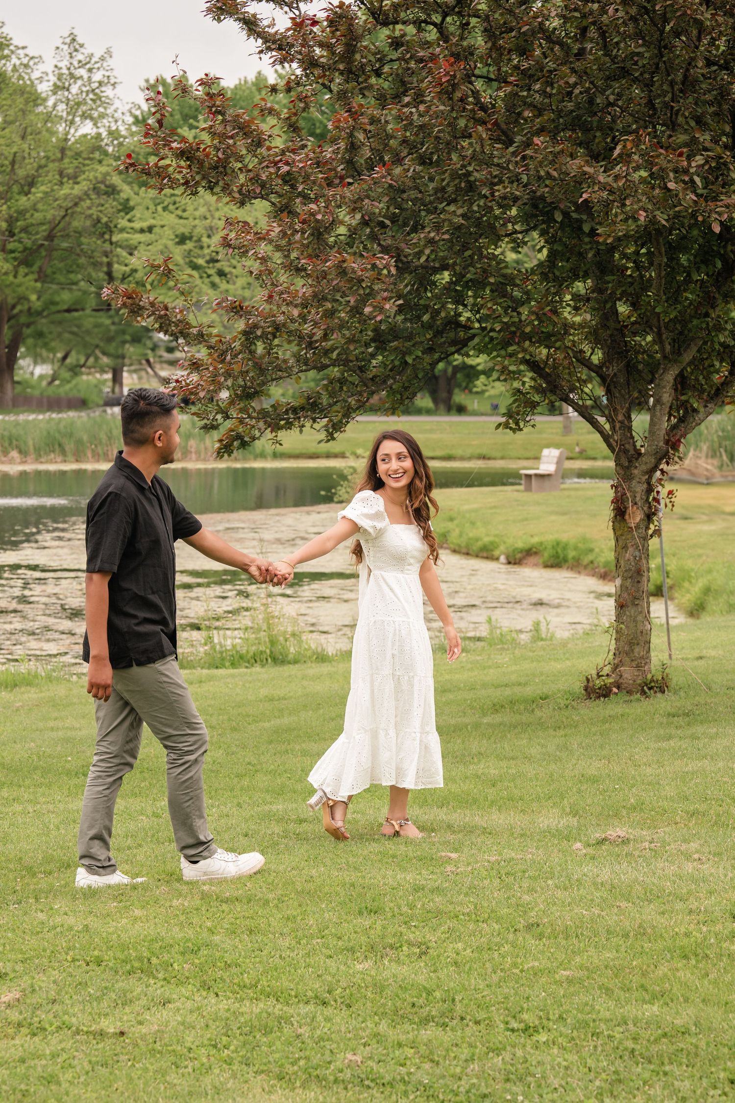 A playful sequence shows a couple dancing and twirling in a park with trees in the background.