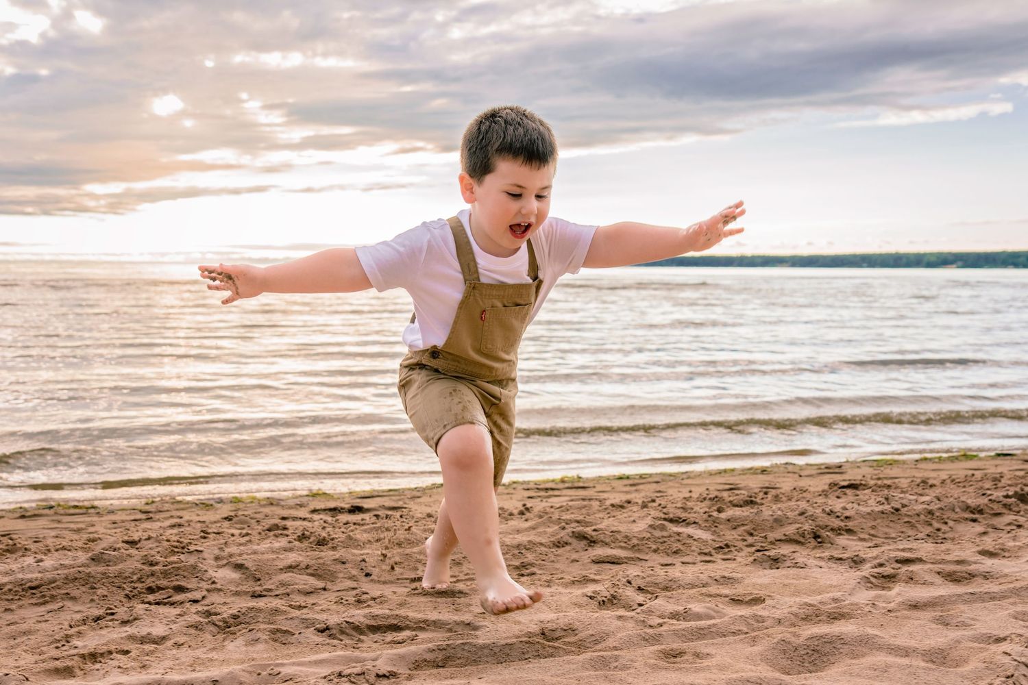A series of beach photos showing a child playing and running along the sandy shore at sunset.